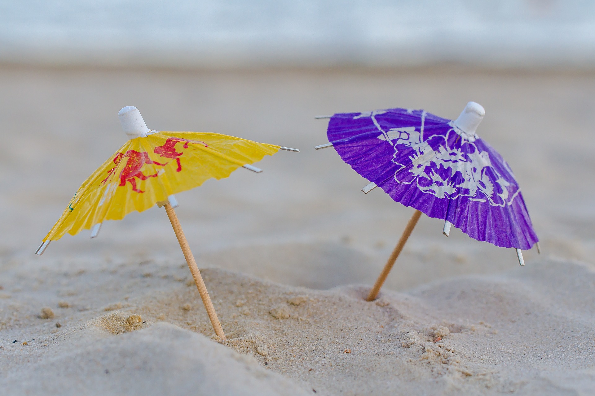 zwei kleine Papierhüte im Sand