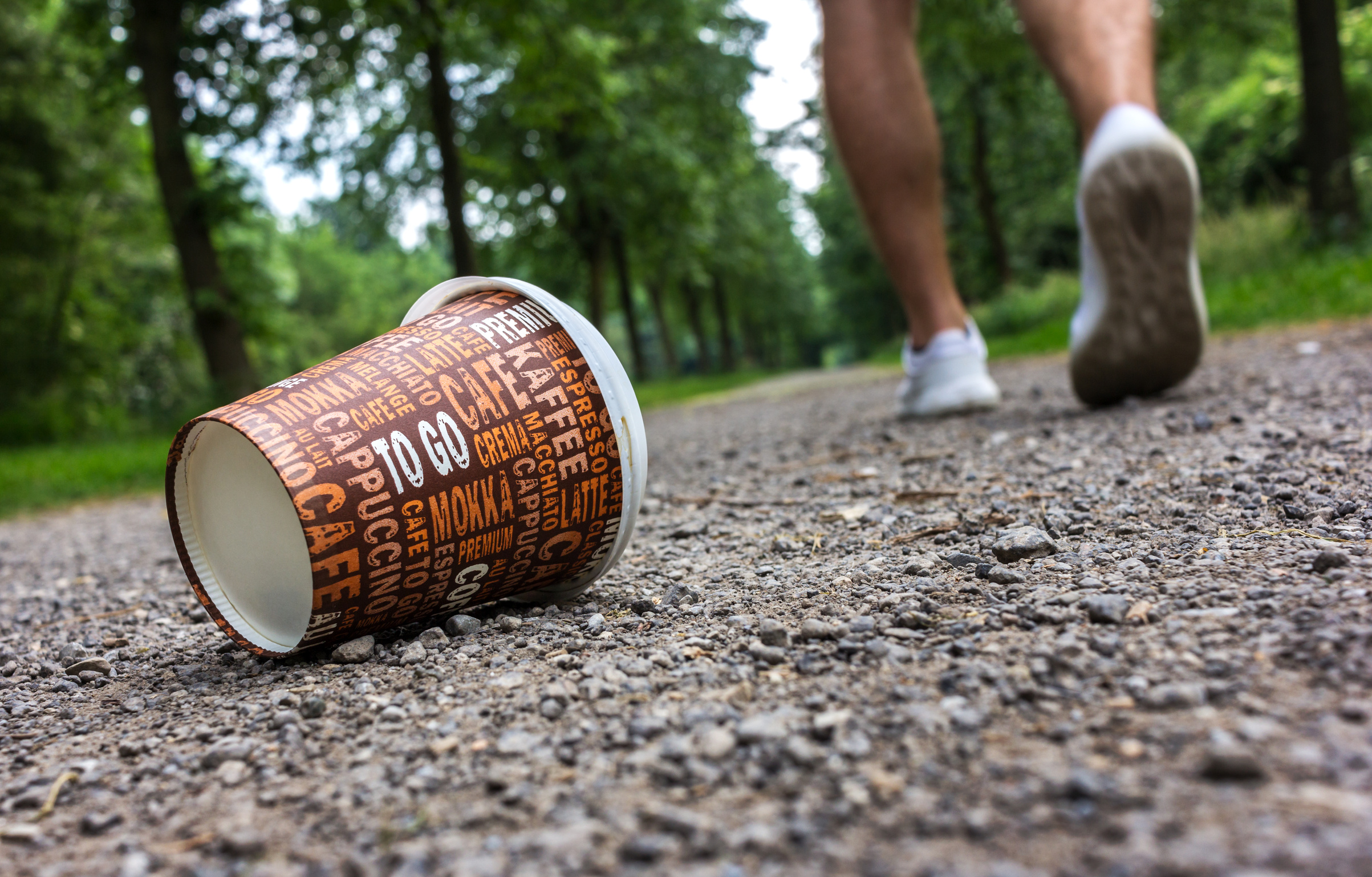 Recyclingseparate abfallsammlung hand wirft eine tasse kaffee in