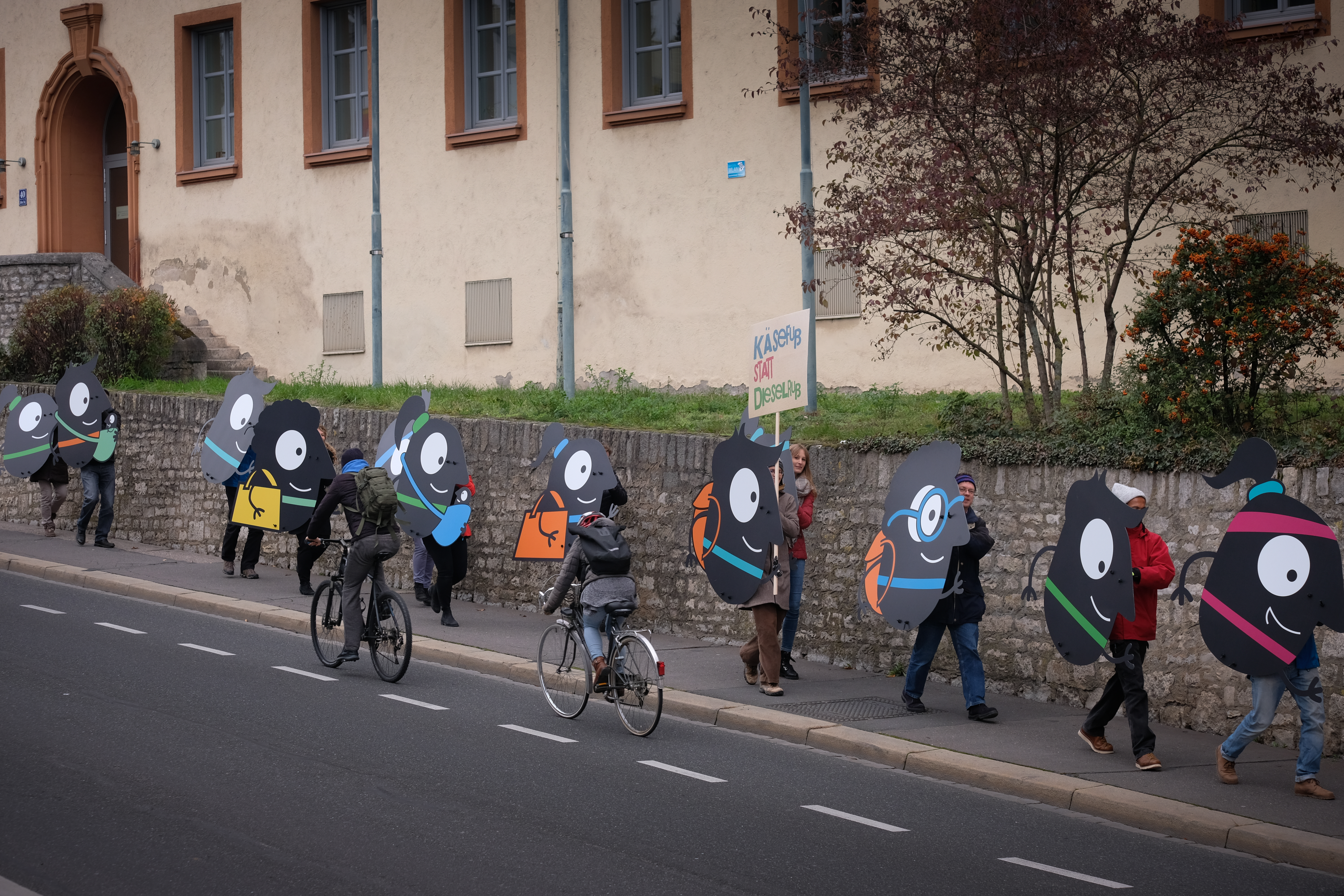 Teilnehmende tragen EMW-Maskottchen Edgar durch Würzburg