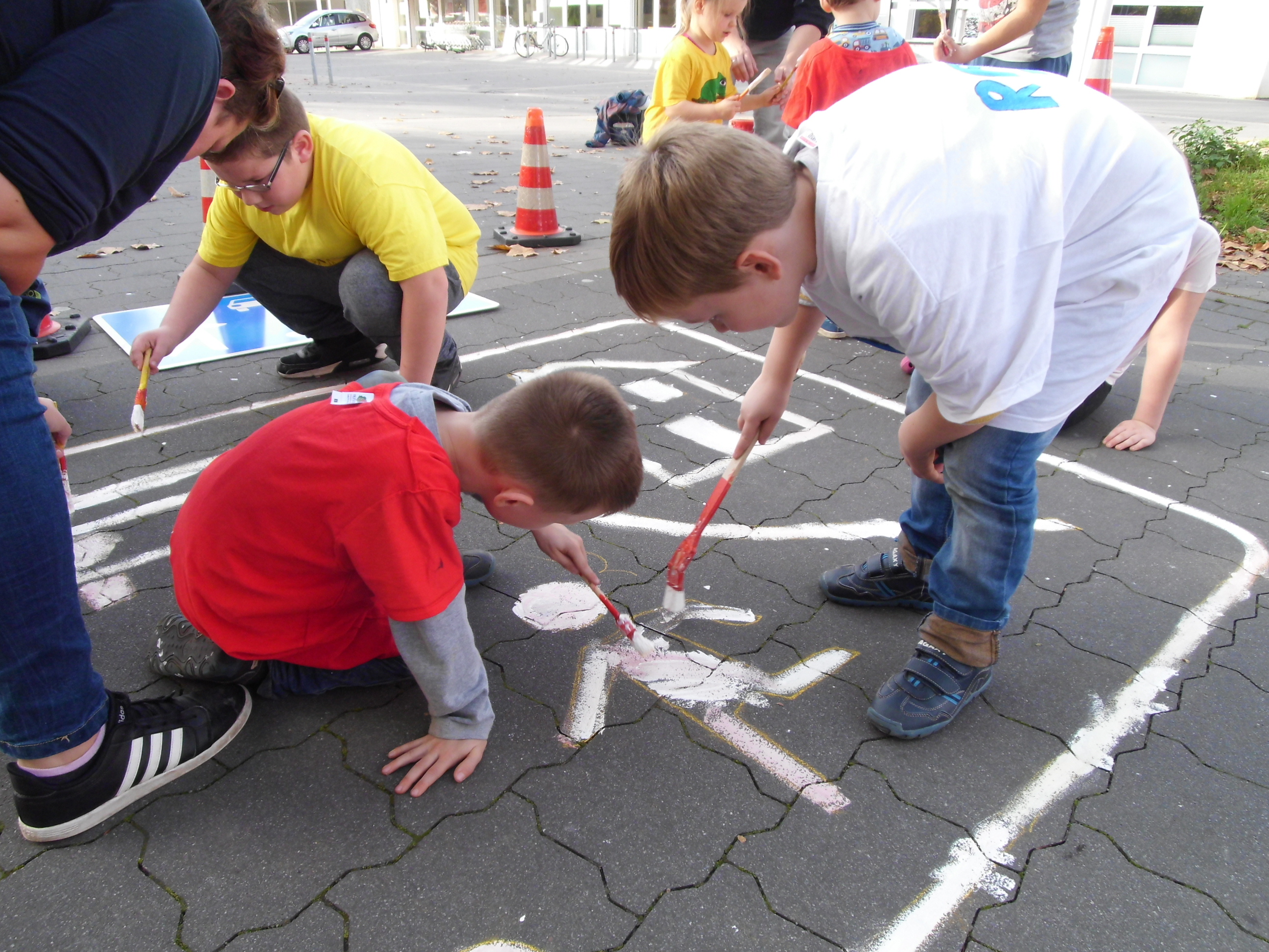 Kinder malen ihr Verkehrszeichen auf den Boden