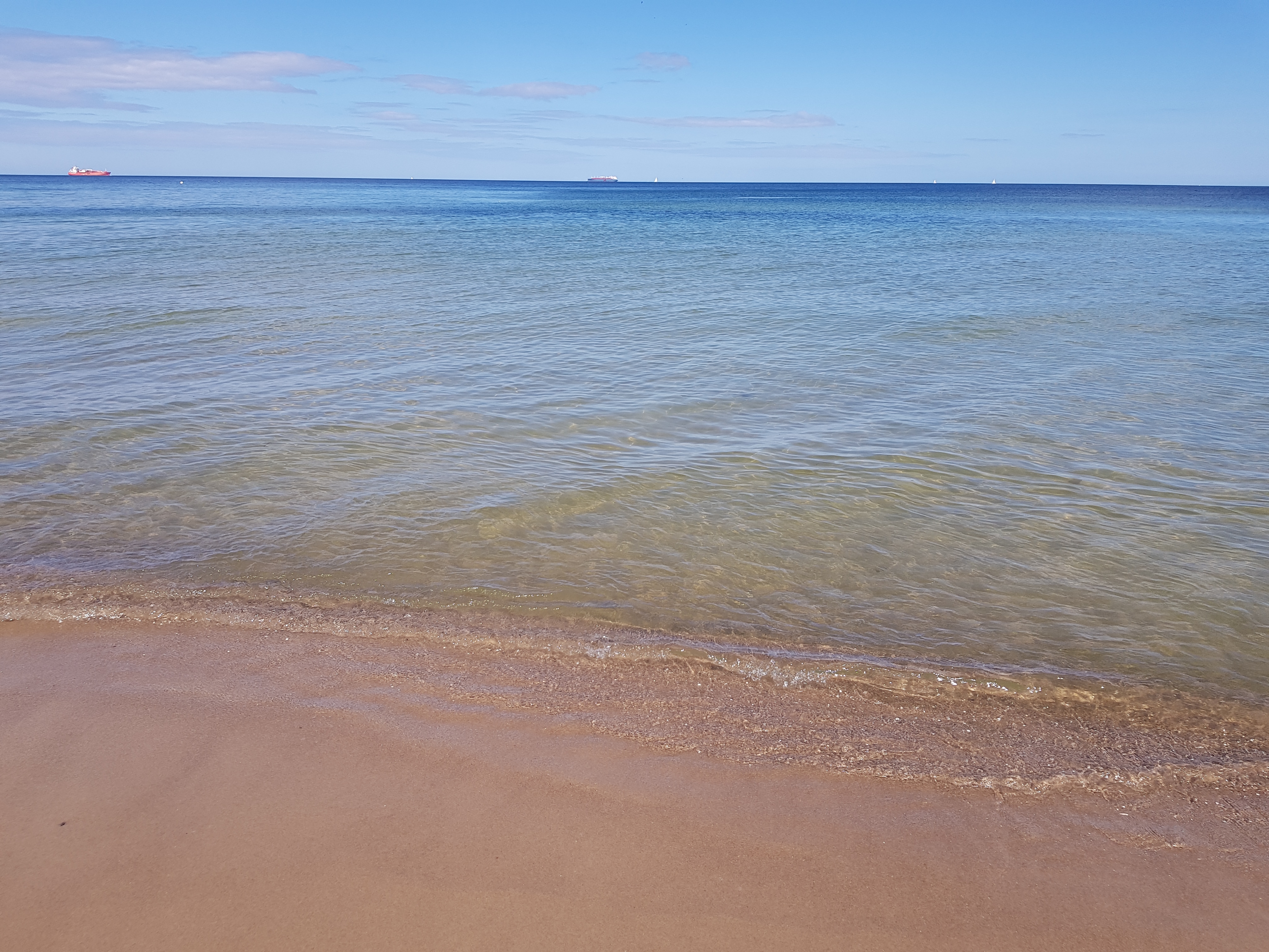 Leerer Sandstrand, kleine Wellen.