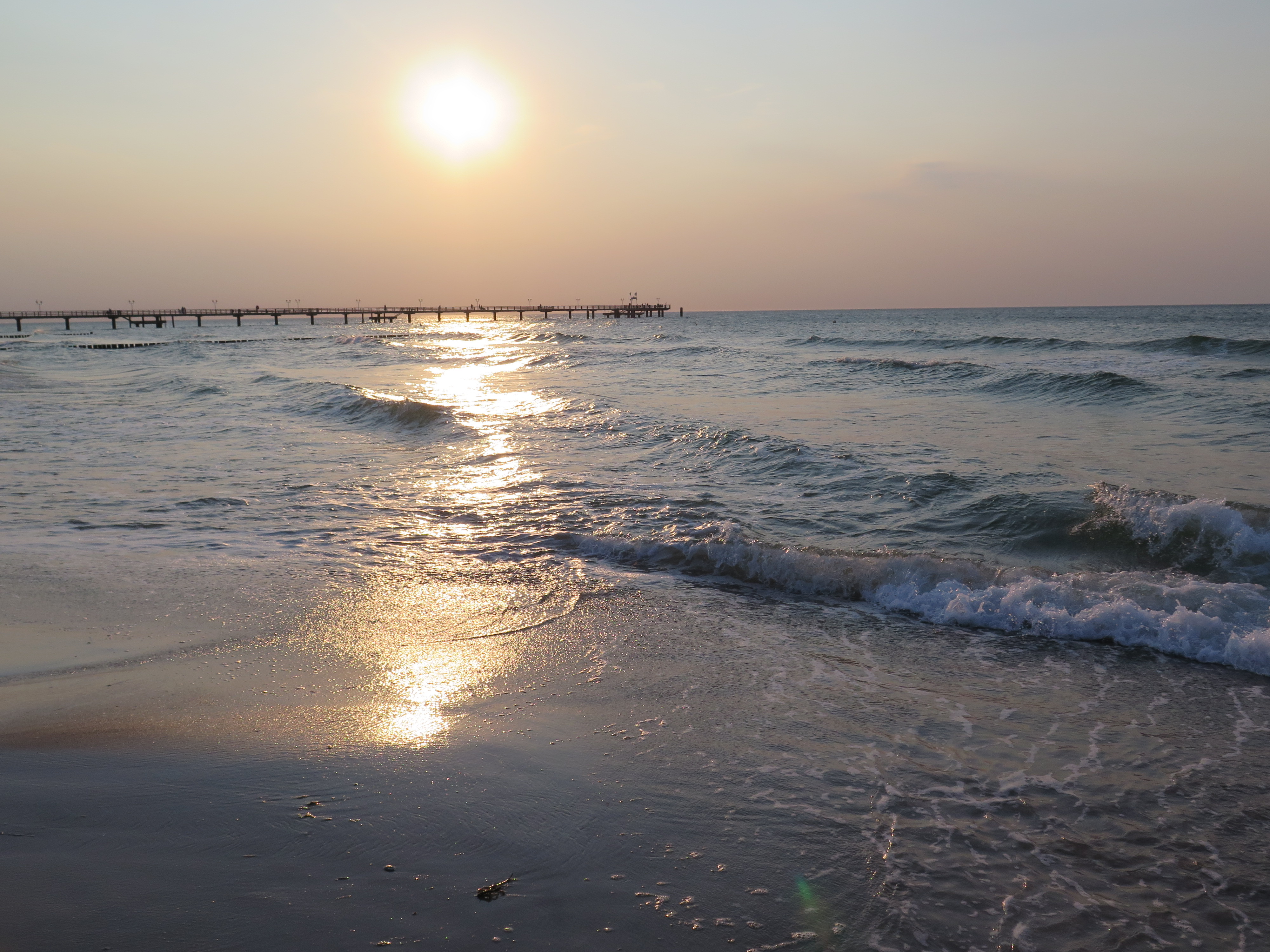 Sandstrand mit Brücke im Hintergrund. 