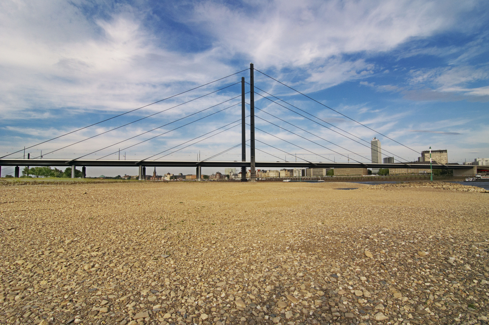 Eine Autobrücke führt über einen teils ausgetrockneten Fluß.