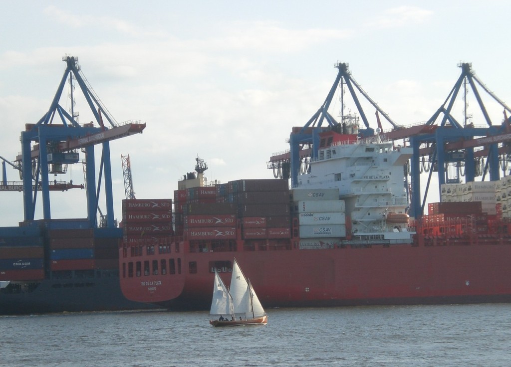 Sailing boat and container ship in the harbor of Hamburg