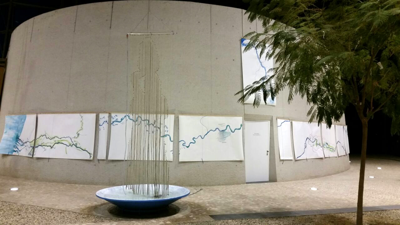 Kunstinstallation im Vorraum des UBA Dessau: über einer großen Schale hängt ein Vorhang aus Schnüren, an dem Wasser herunterläuft, man erkennt die Silhouette eines Menschen