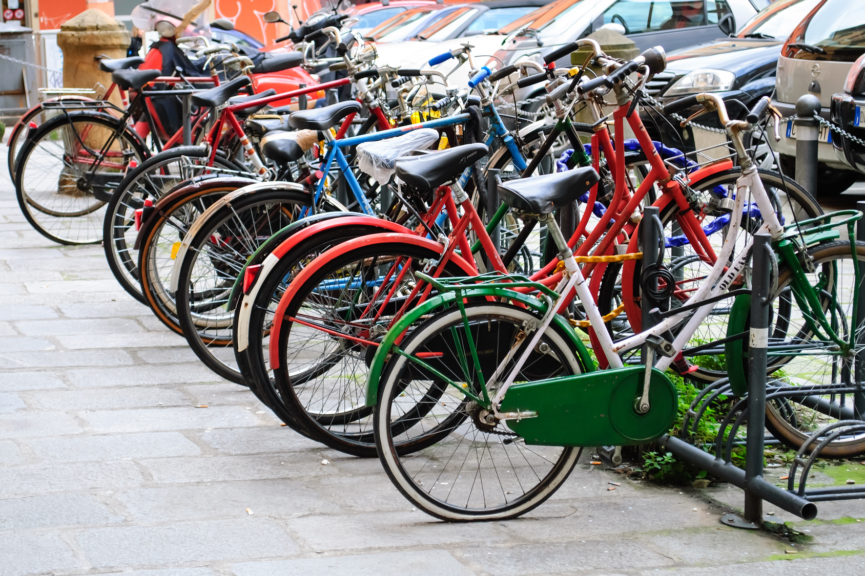 a lot of colourful bicycles in a bicycle stand