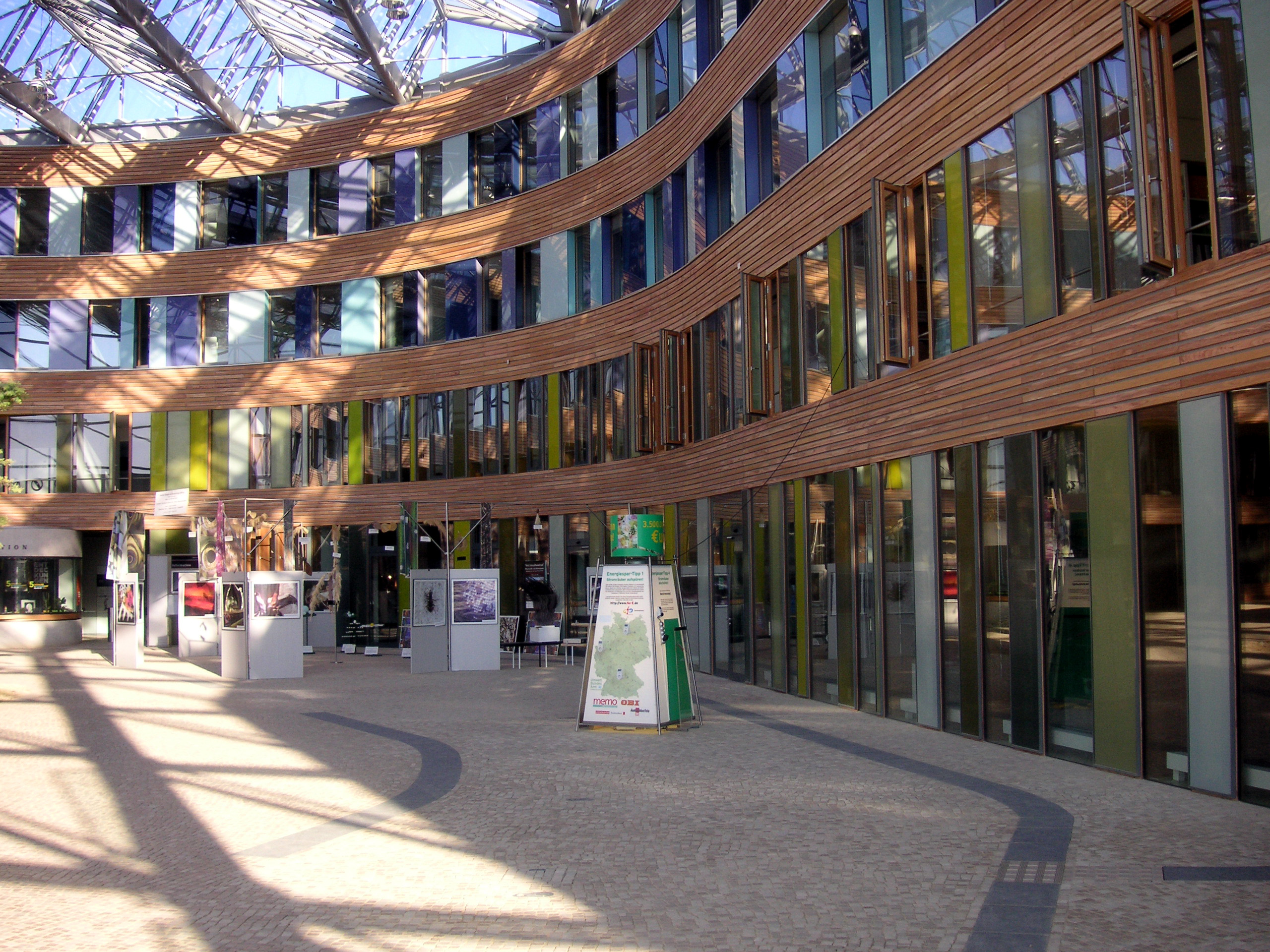 Der gepflasterte, mit Glas überdachte Eingangsbereich des UBA-Dessau-Roßlau mit Exponaten einer Ausstellung