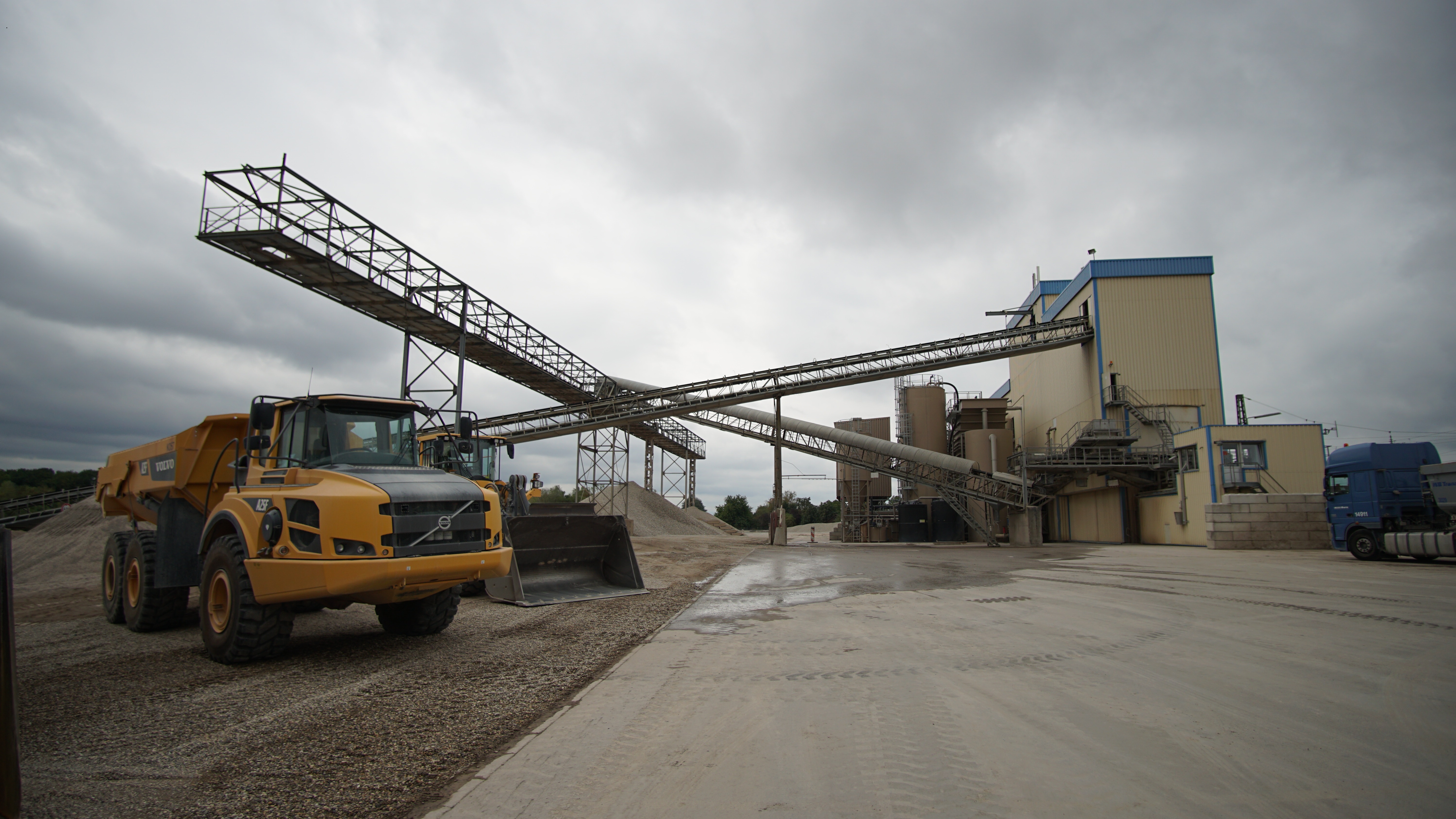 Foto einer Industrieanlage, davor zerkleinertes Gestein und ein Muldenkipper