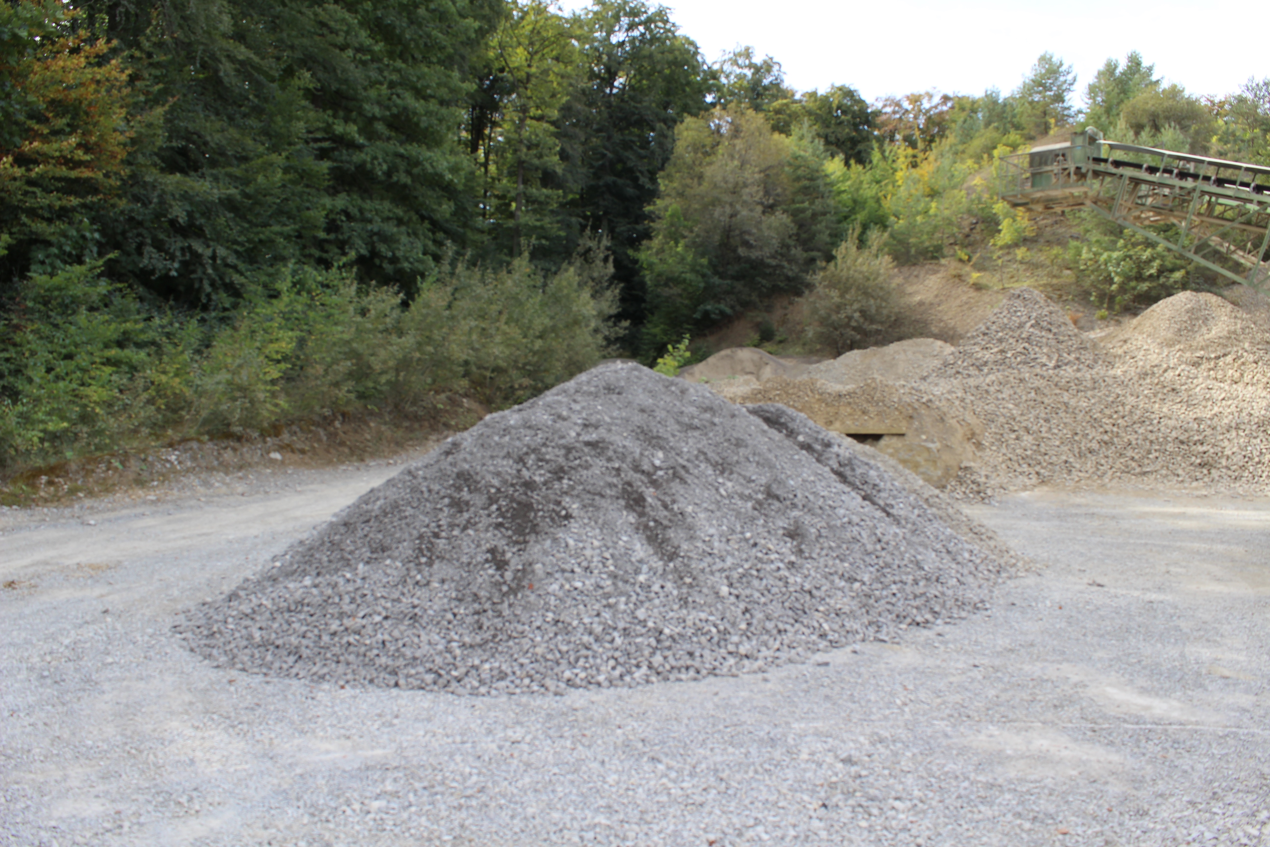 Im Vordergrund ein Haufen kleiner grauer Steine, im Hintergrund ein Haufen kleiner gelblicher Steine