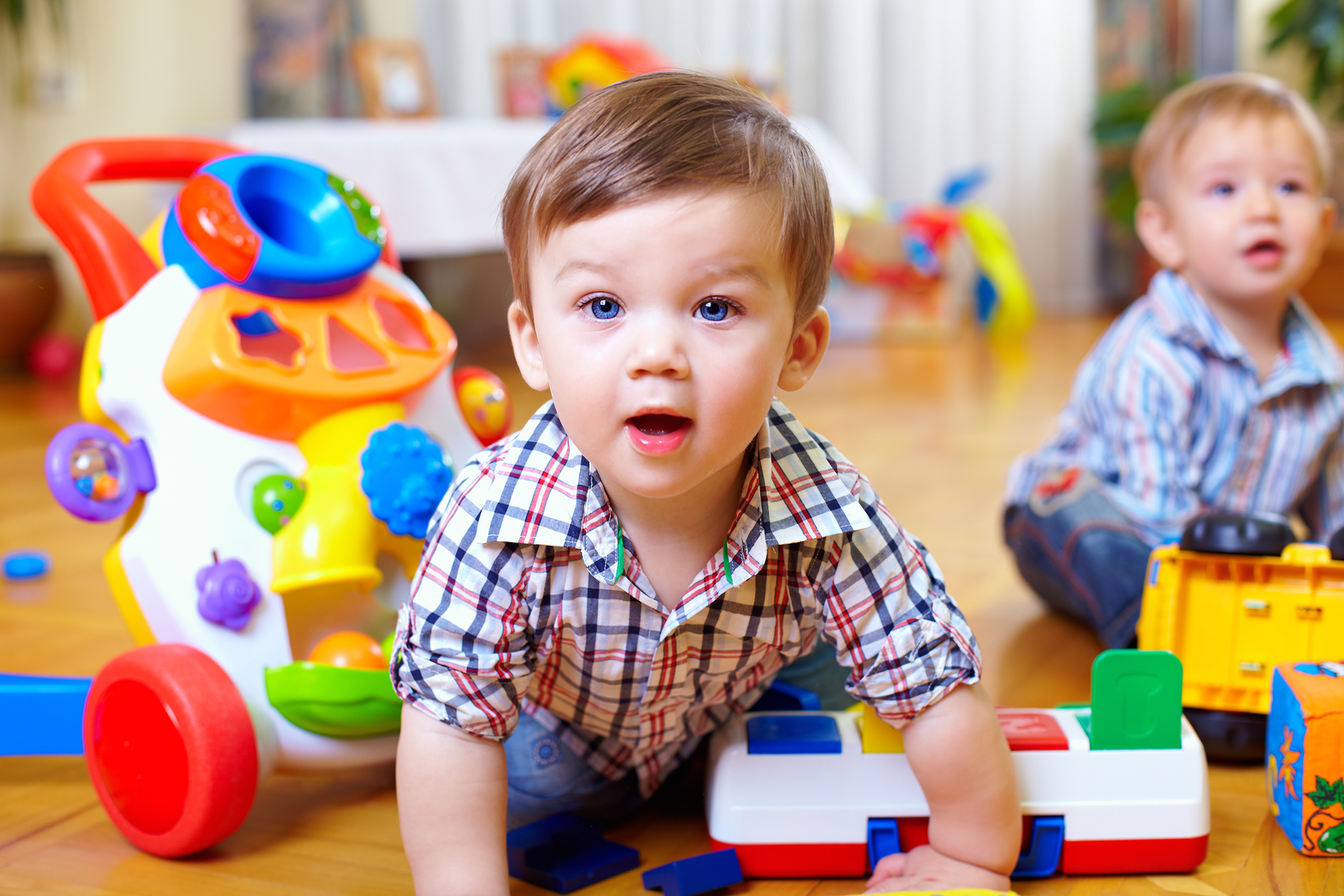 two little boys are playing with plastic toys on the floor