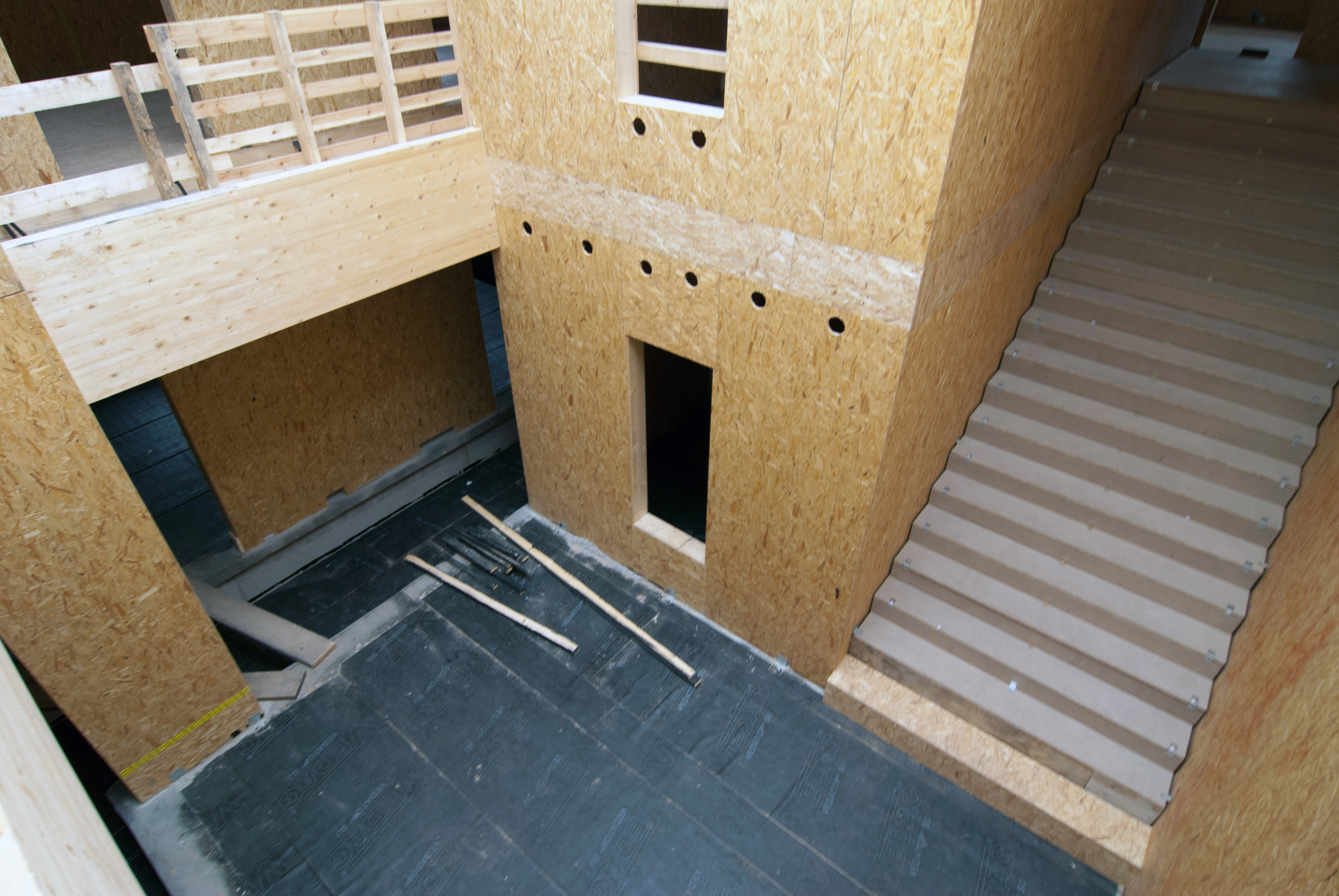 Treppenhaus, die Innenwände aus noch rohen Holzwerkstoffplatten