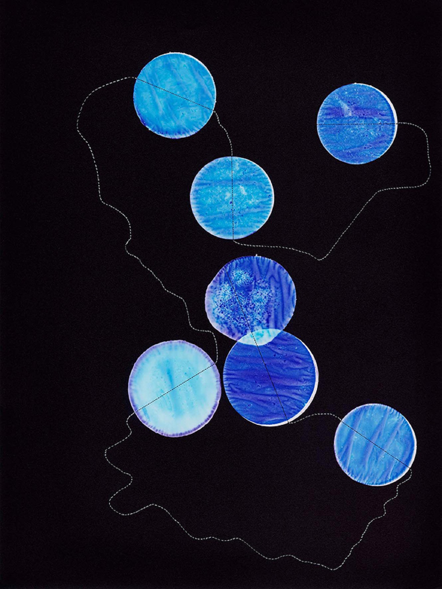 runde, blaugefärbte Stoffstücke mit einem Faden verbunden vor schwarzem Hintergrund