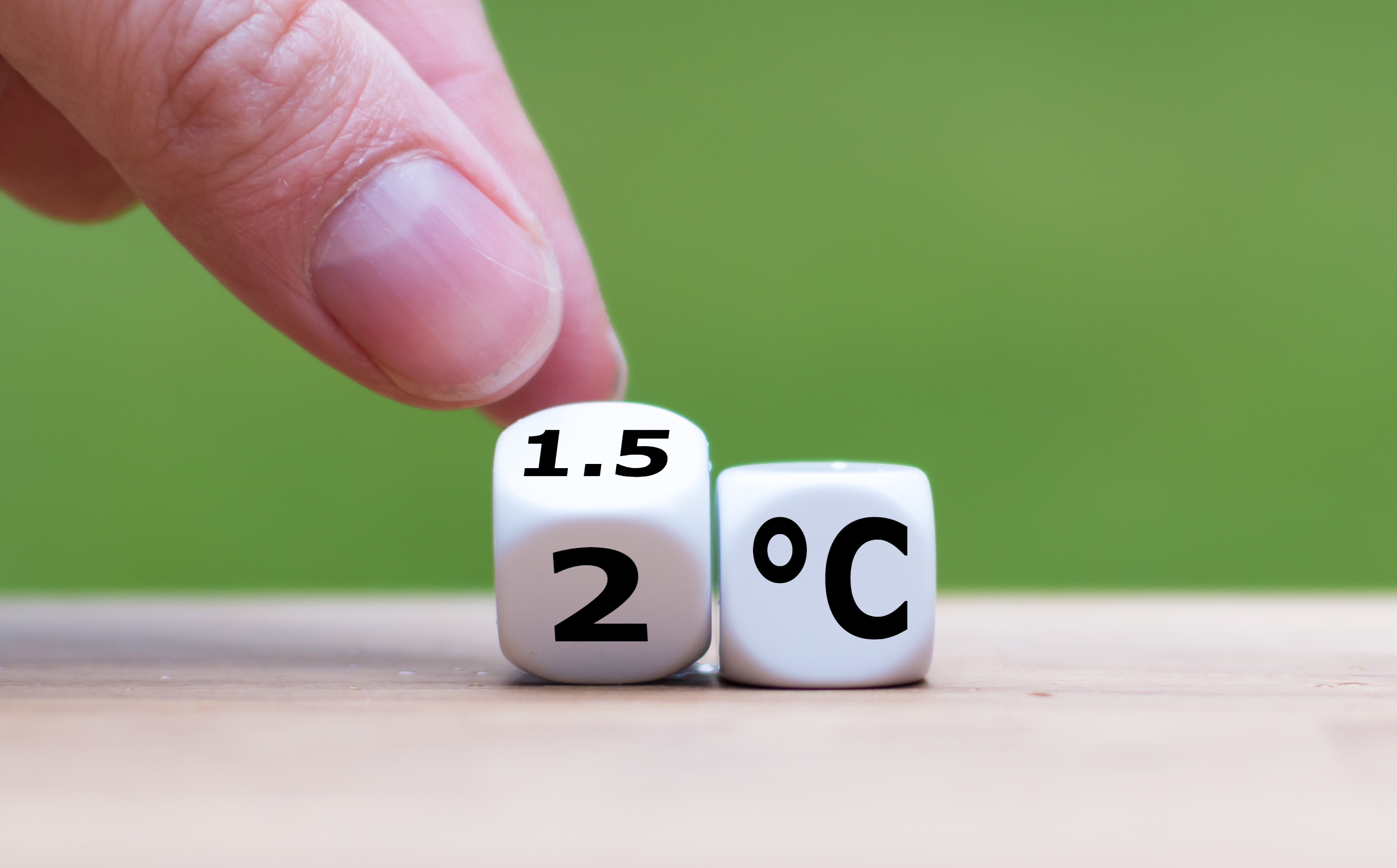 ein Finger kippt einen Würfel an, auf dem vorne eine 1.5 und unten eine 2 steht, daneben ein Würfel mit der Aufschrift °C