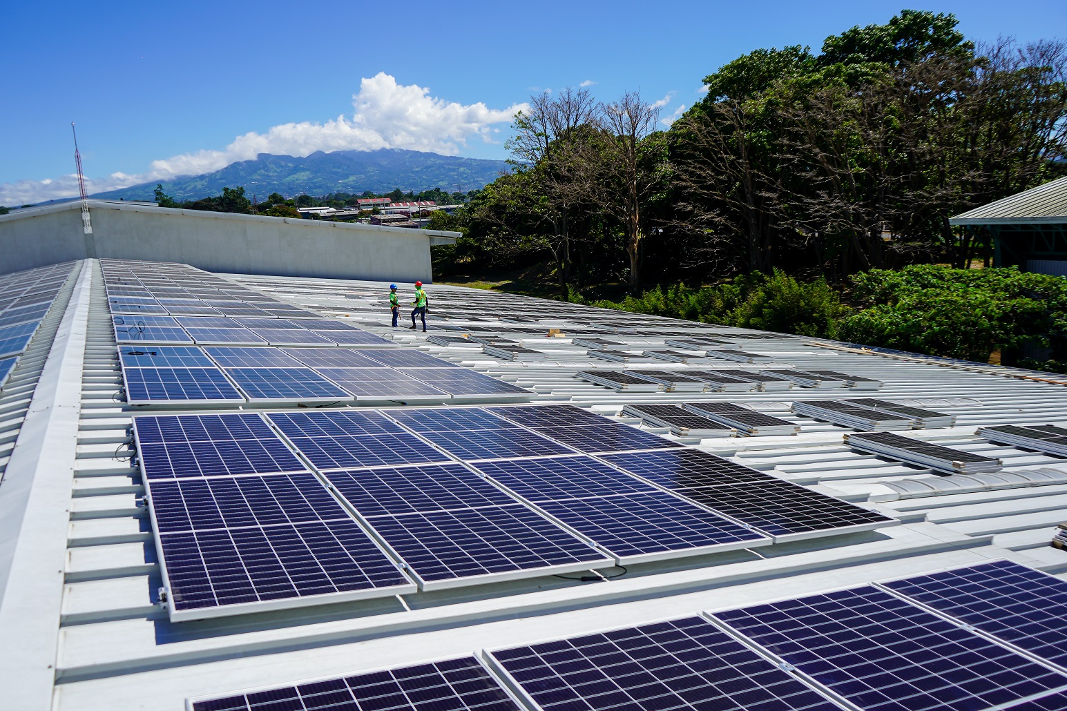 A photovoltaic system is installed on the roof of a warehouse