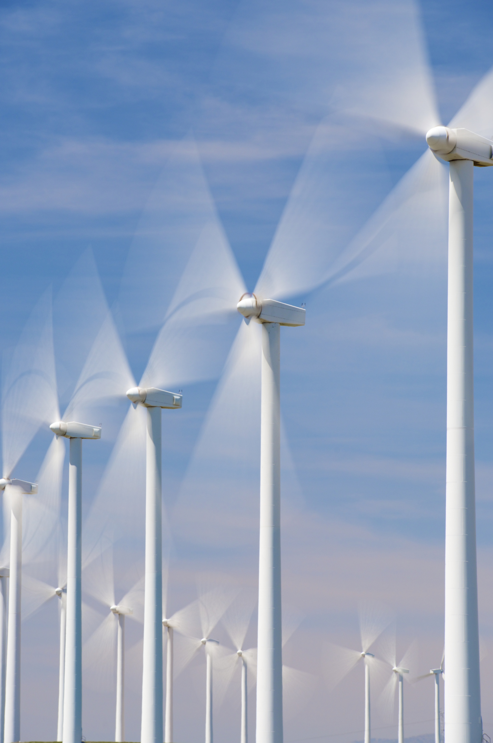 Windkraftanlagen drehen sich vor blauem Himmel