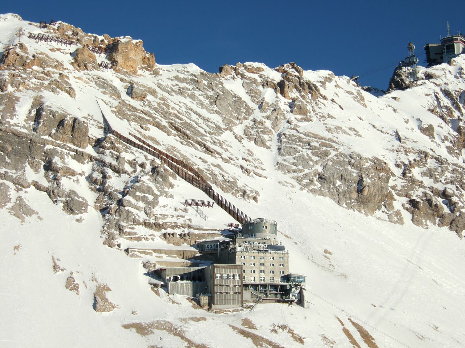 Messstationsgebäude an einem schneebedeckten Berghang