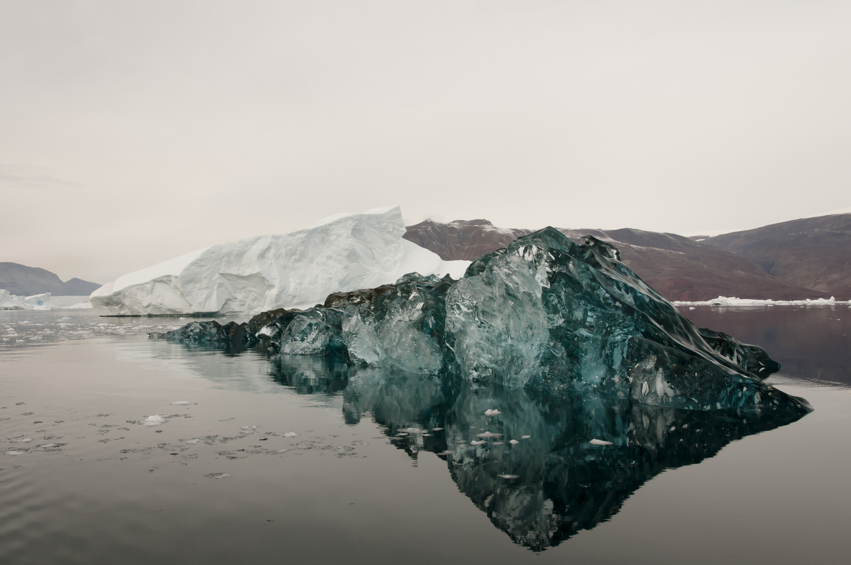 schwarz gefärbter Eisberg im Wasser 