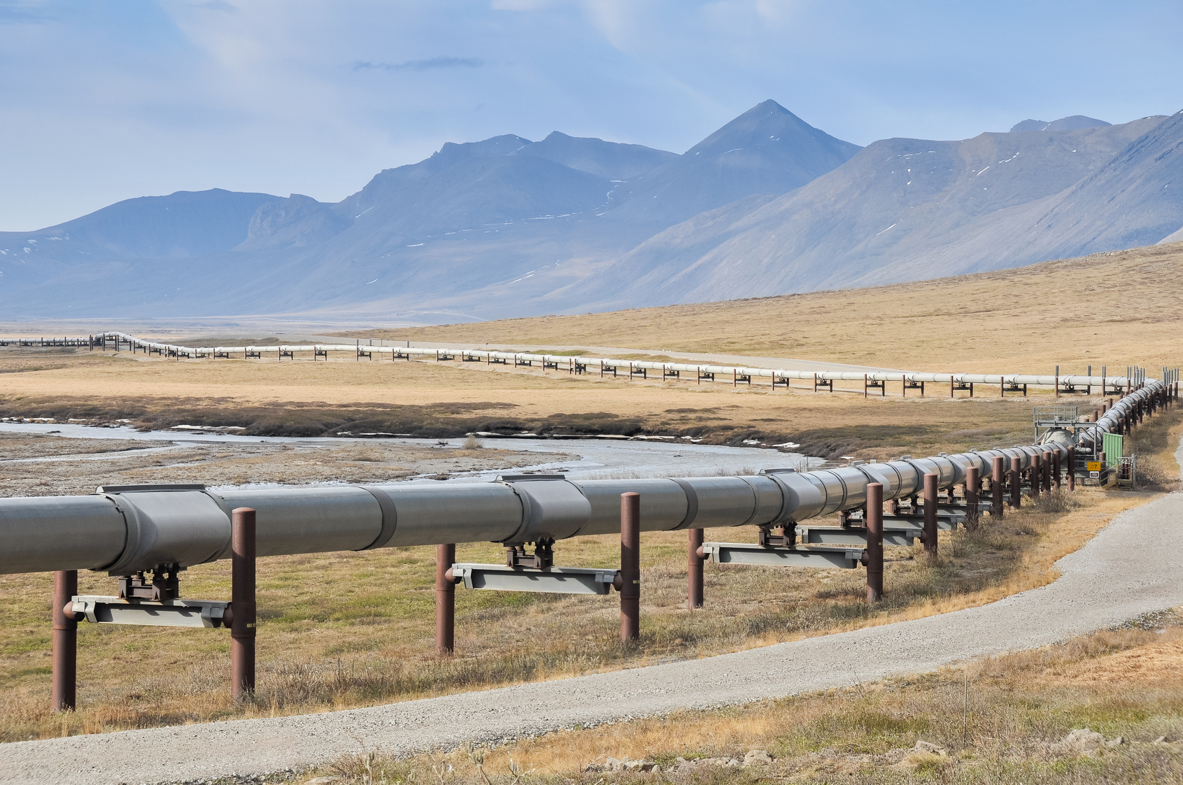 Ölpipeline, im Hintergrund Berge 