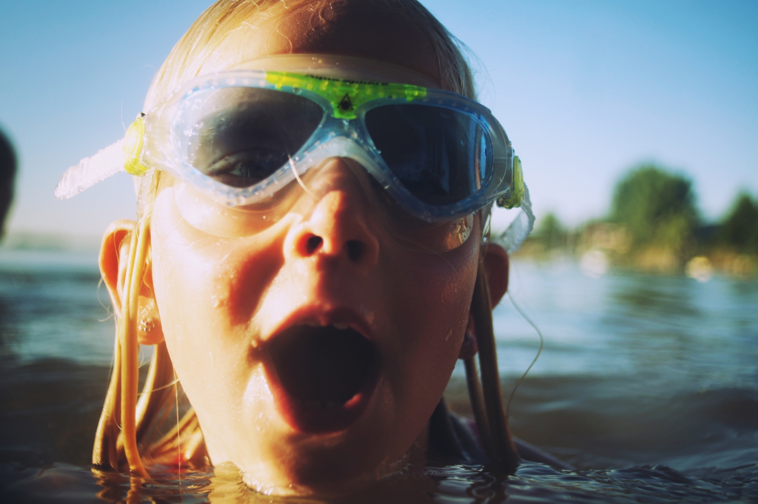 Ein Mädchen schwimmt im offenen Wasser: Sie trägt eine Schwimmbrille.
