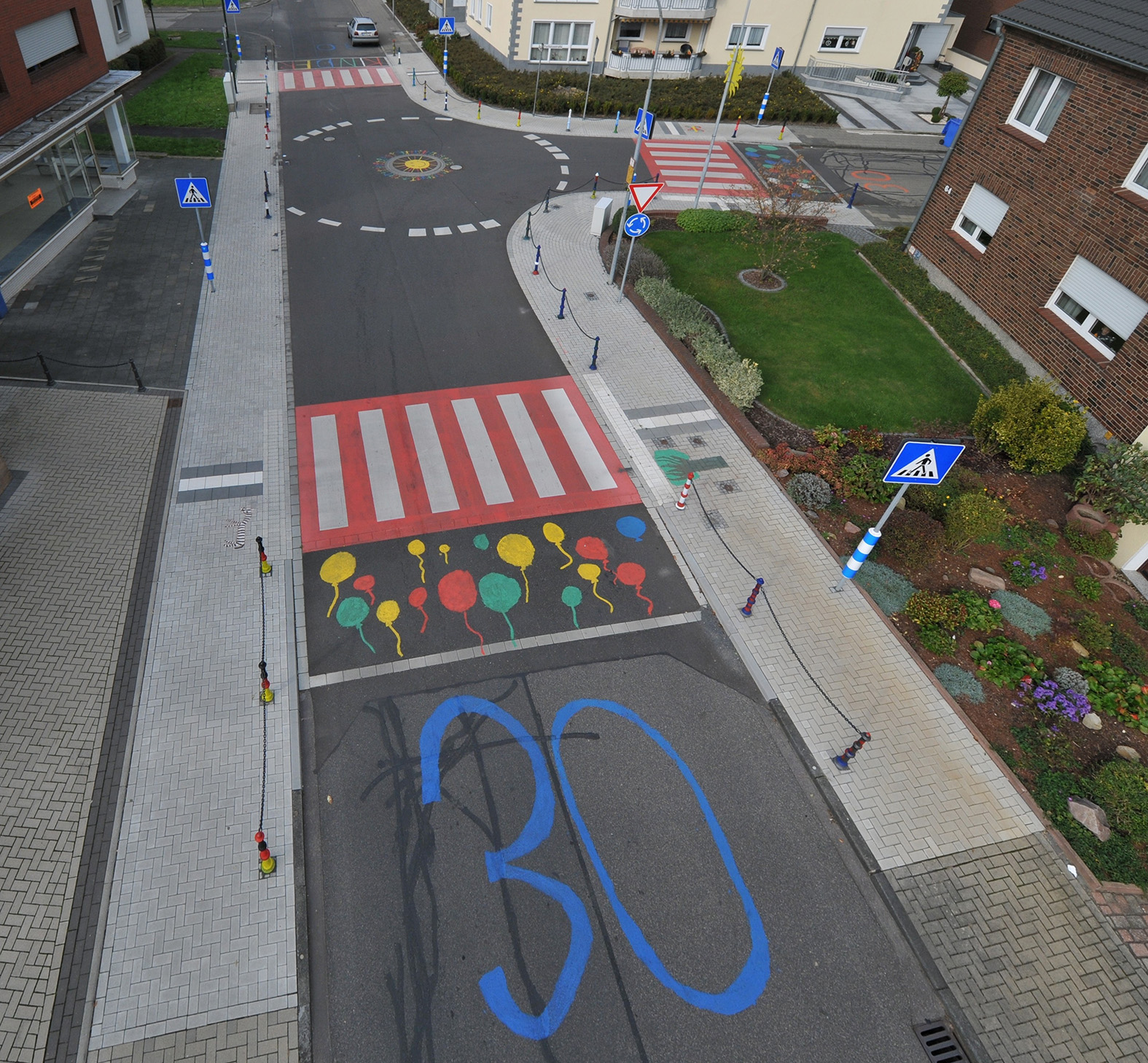 Blick auf die bunt gestaltete Kreuzung mit markierten Zebrastreifen und 30-er-Zone