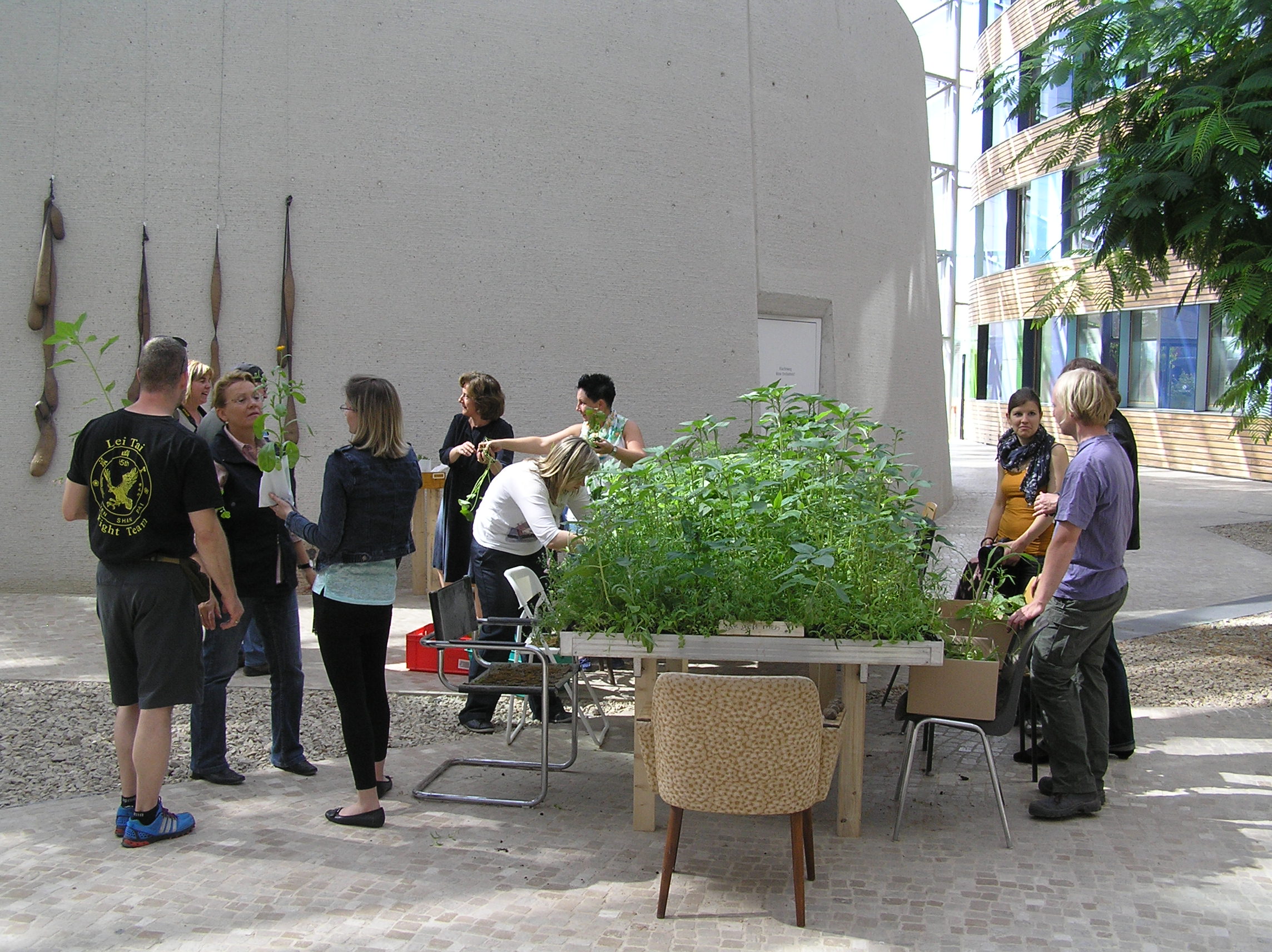 Forum des UBA: Garteninstallation mit hochgewachsenen Pflanzen und Menschen, die diese besichtigen