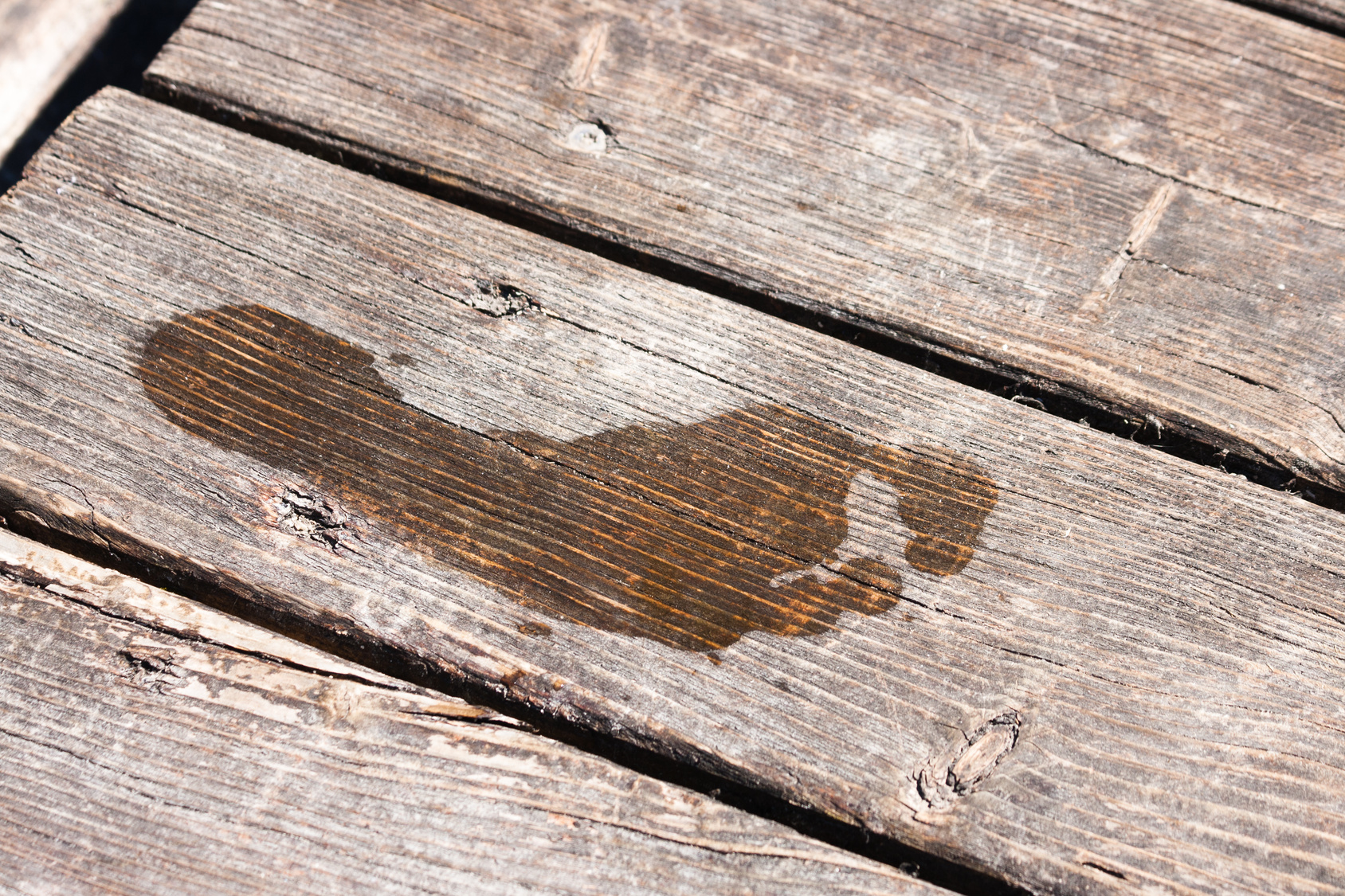 Abdruck eines nassen Fußes auf einem Bootssteg aus Holz