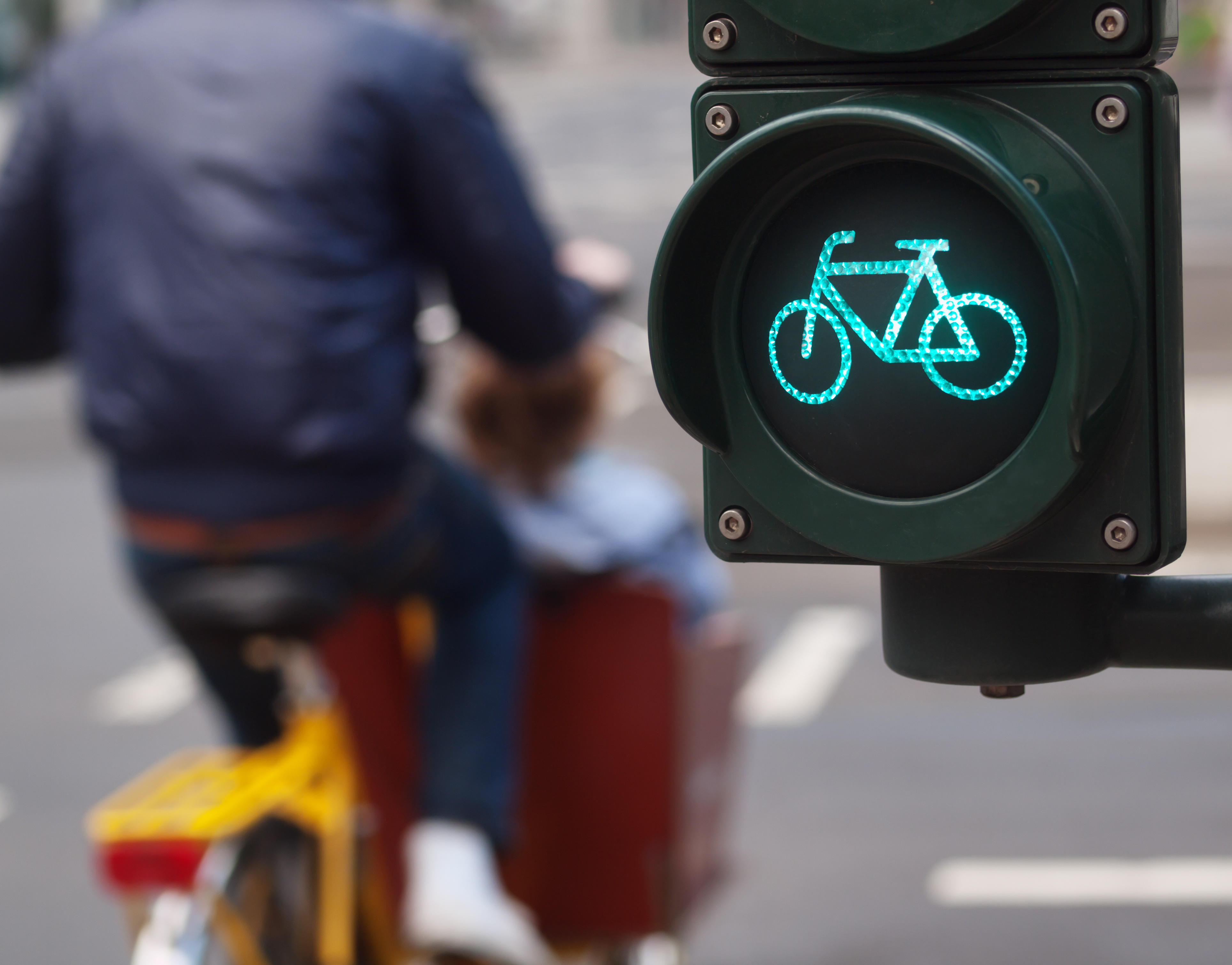 Fahrradampel steht auf Grün, Mann mit gelbem Rad ist vorbeigefahren