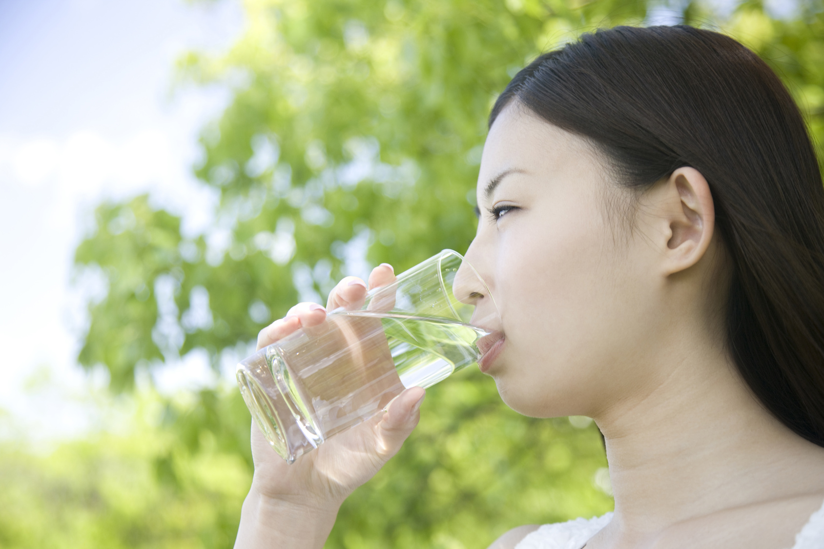 Frau trinkt Wasser aus einem Glas