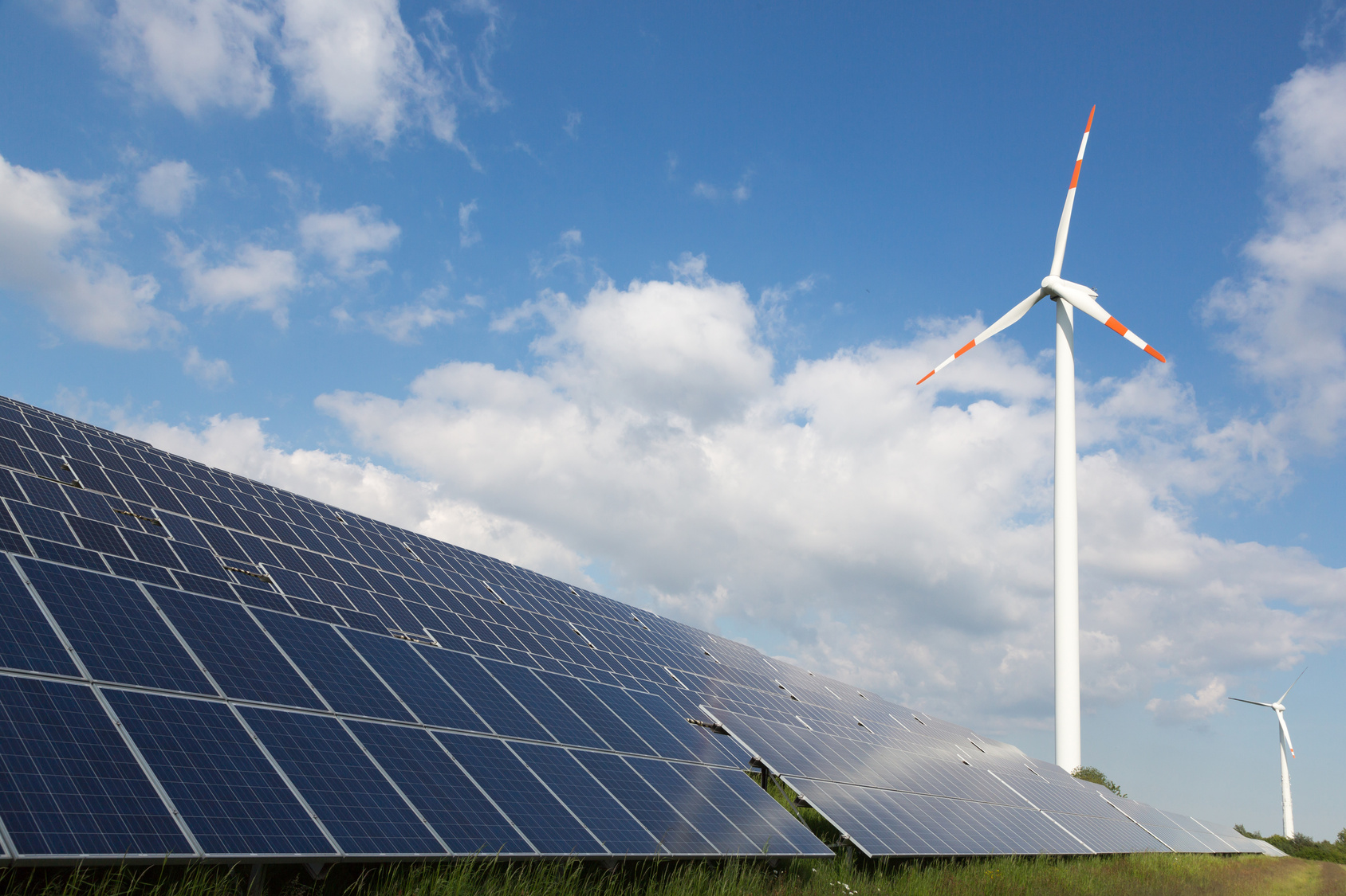 Windkraftanlagen und Solarpanels auf einer Wiese