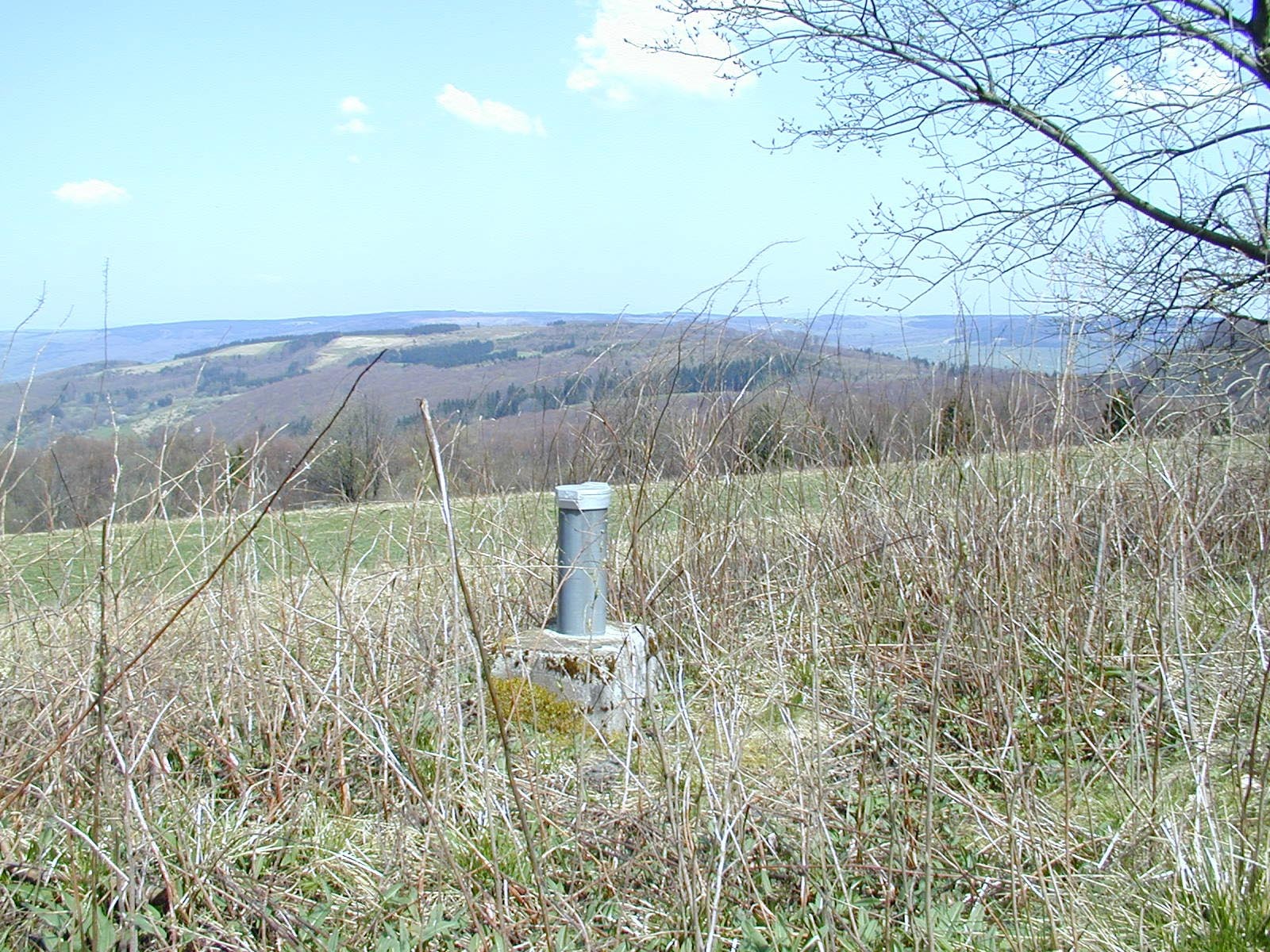 Grundwassermessstelle vor Landschaft.