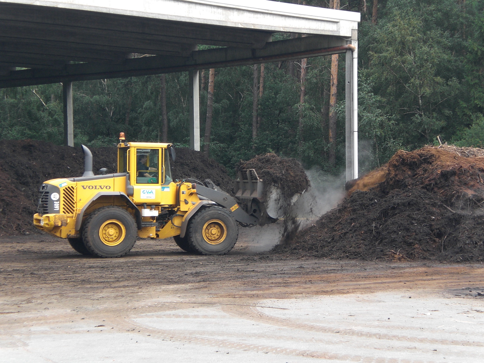 A yellow wheel loader implements composting in a composting plant.