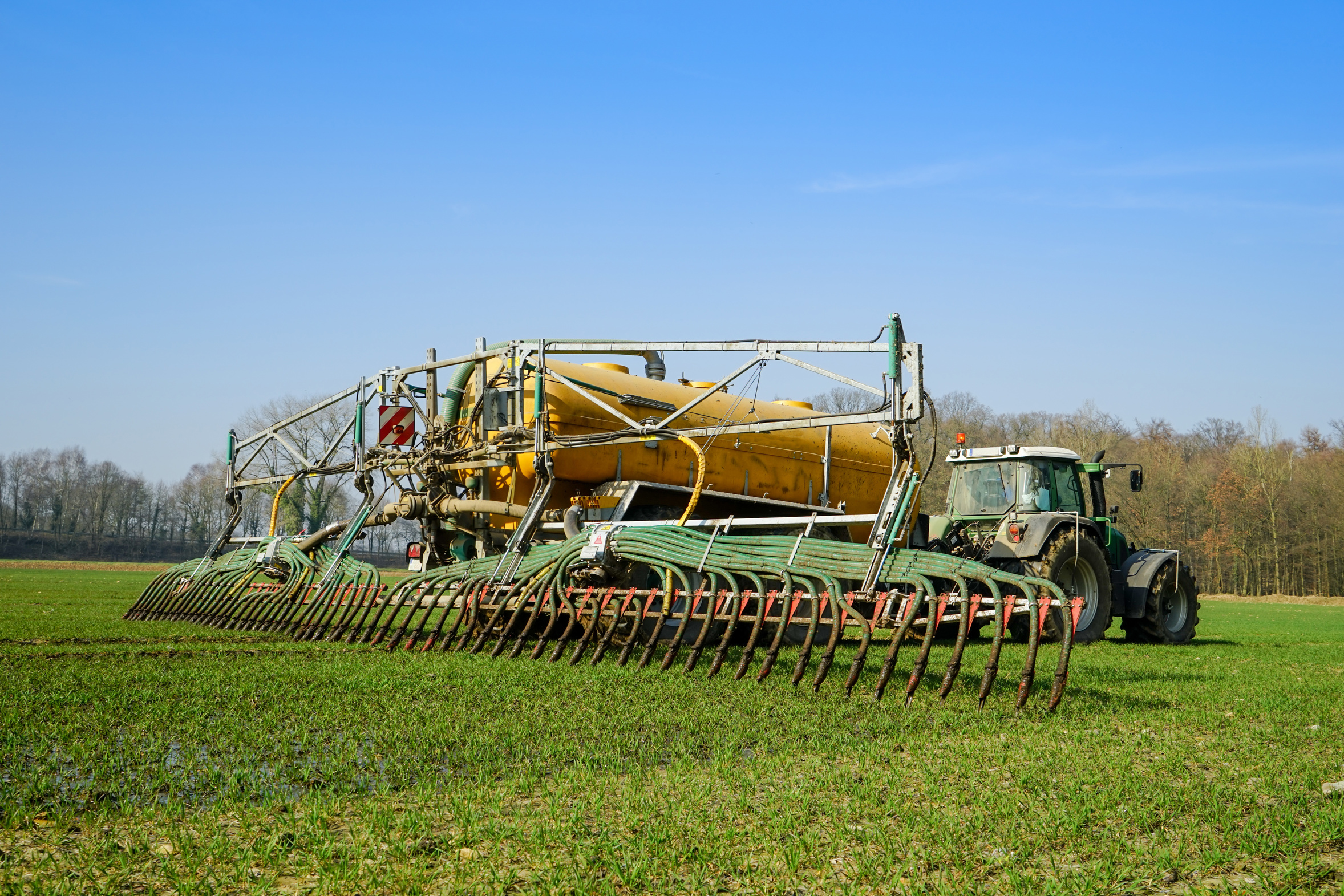 Ein Traktor bringt Gülle auf einem Feld aus