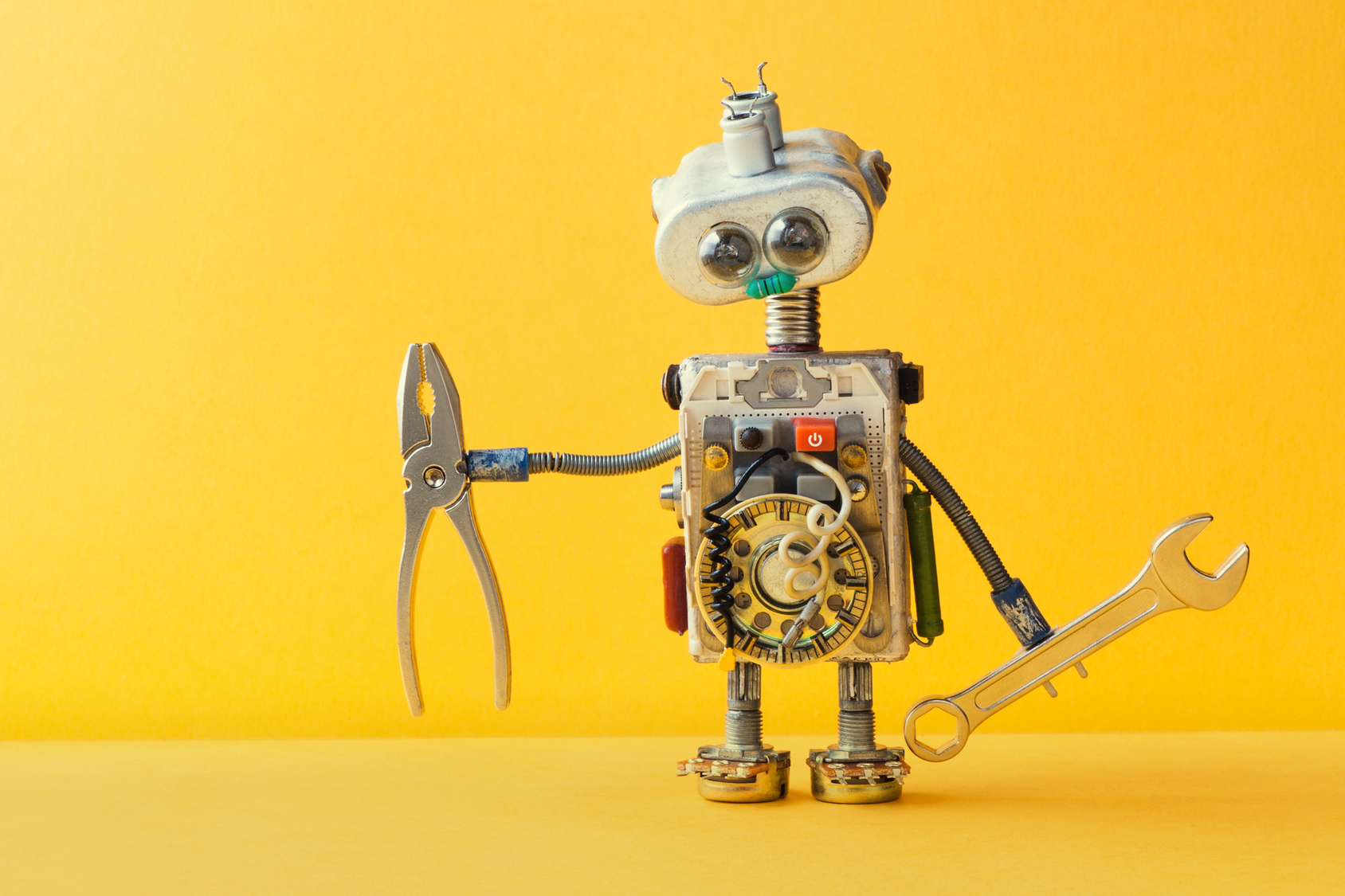 Ein Roboter mit Werkzeug in der Hand auf gelbem Hintergrund
