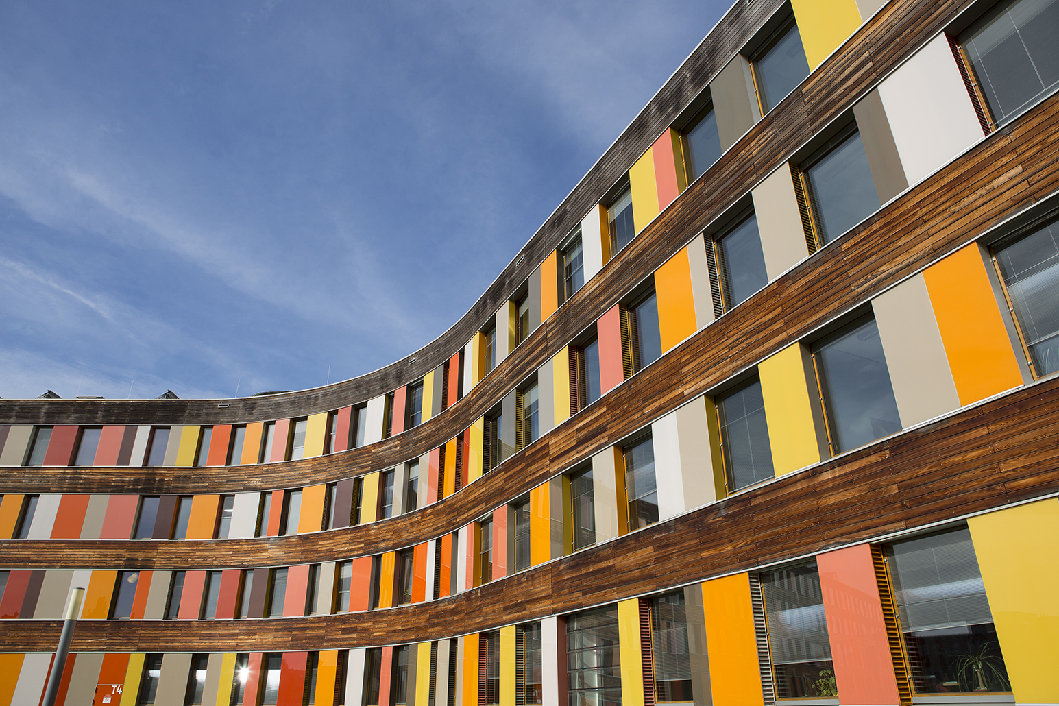 Rückwärtige Holz-Fassade des UBA Dessau-Roßlau mit Glasplatten in verschiedenen Rottönen