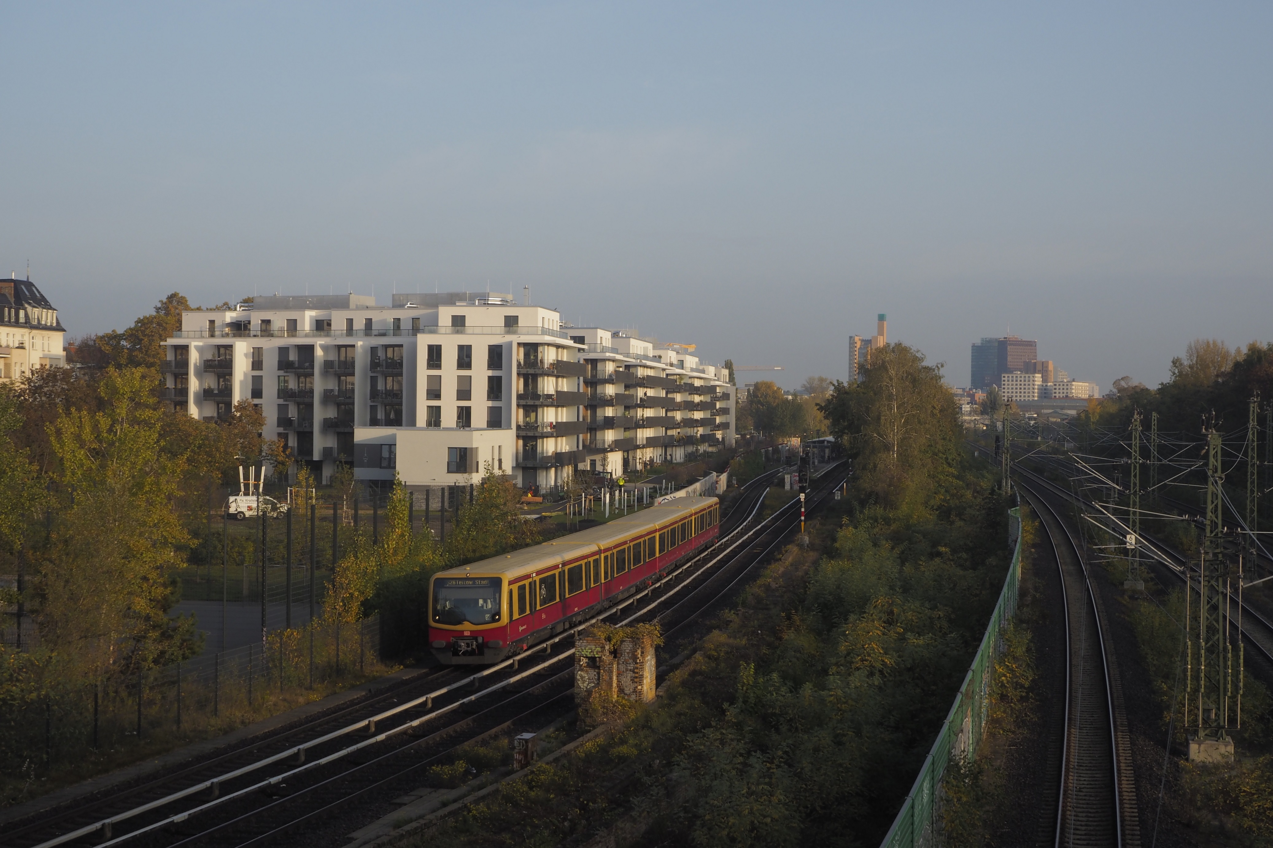 Blick auf Schienen mit einer S-Bahn, dahinter Stadtpanorama