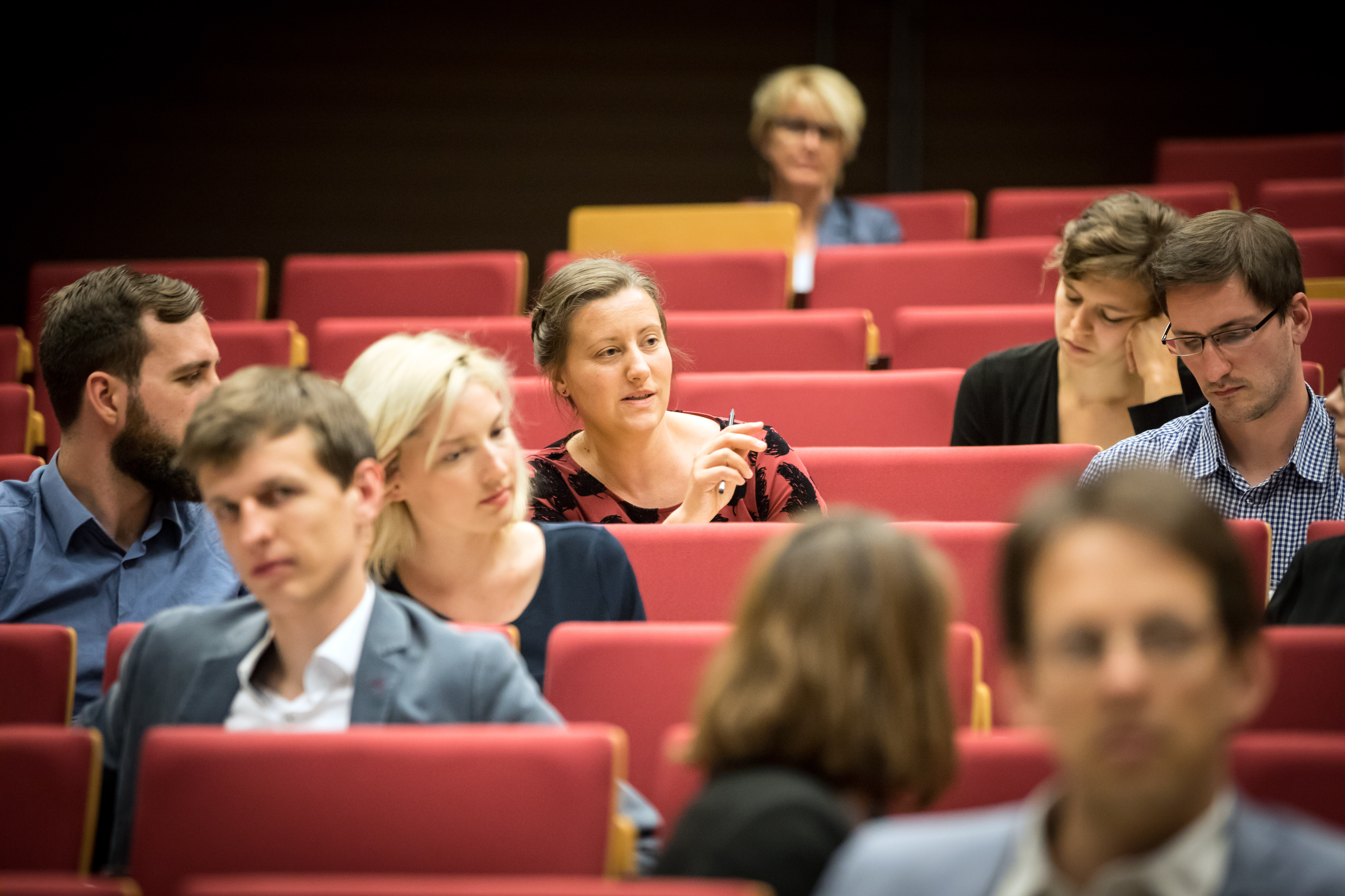 Blick auf miteinander diskutierende Veranstaltungsteilnehmerinnen und -teilnehmer  im Hörsaal.