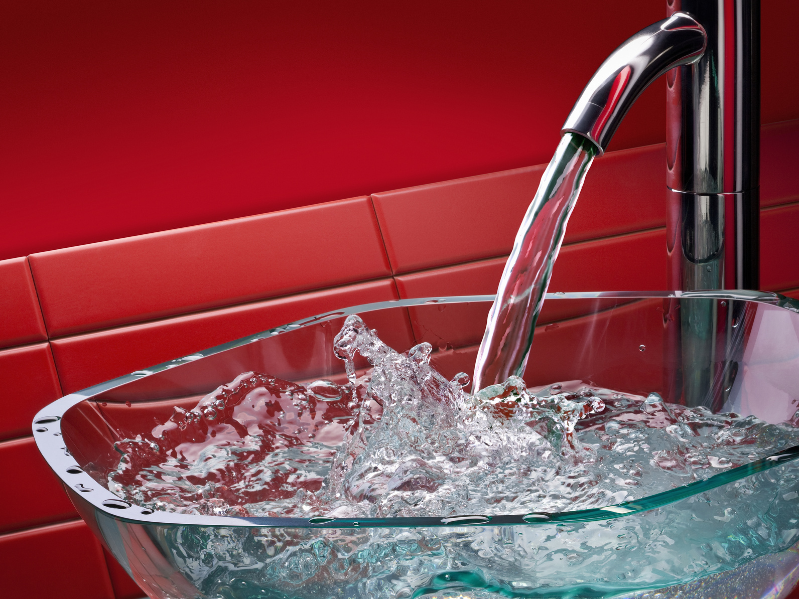 Laufender Küchenwasserhahn mit Glasschale, roter Hintergrund