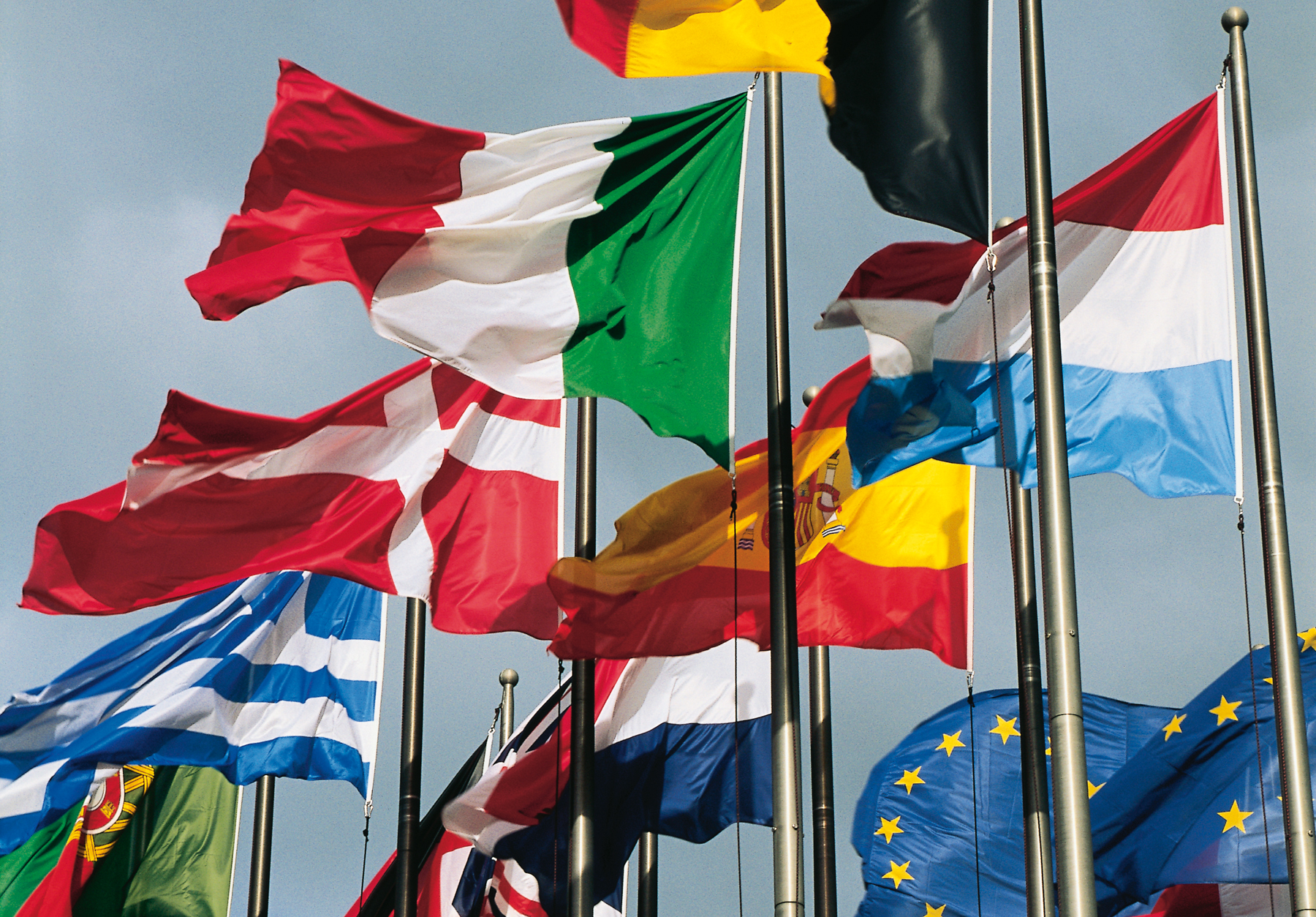 wehende Flaggen der Länder Schweiz, Griechenland, Spanien, Luxemburg, Italien, Niederlande, Portugal, England und Belgien sowie der Europäischen Union