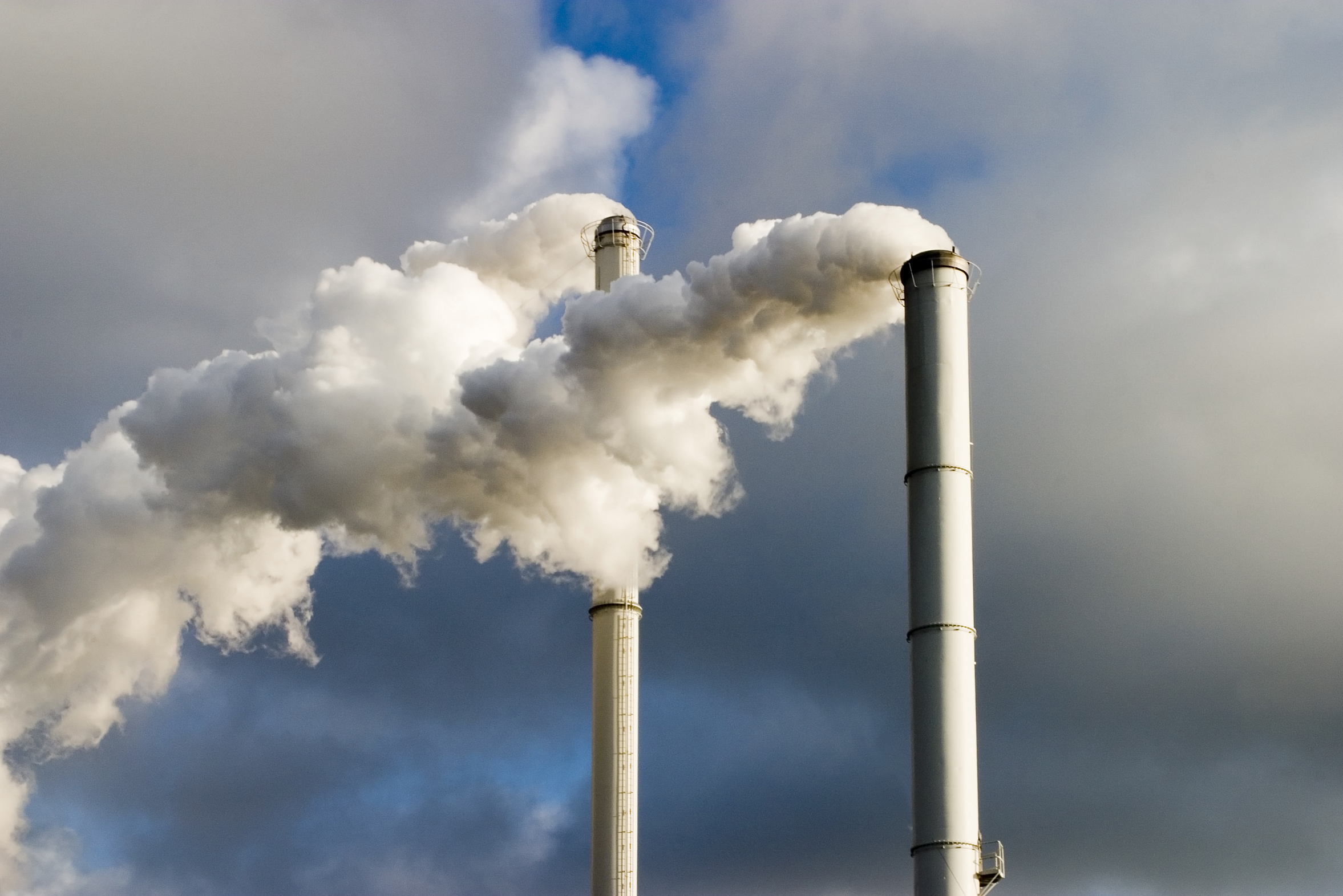 Two chimneys blow out white smoke