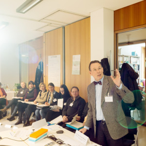 Teilnehmer des Workshops Gesundheit sitzen in einem Stuhlkreis zusammen und hören dem Vortragenden zu