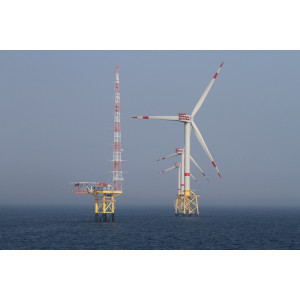 Blick auf drei Offshore Windenergieanlagen in Reihe und der Forschungsplattform FINO 1 daneben