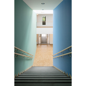 Treppe abwärts mit Holz-Handläufen, die rechts Wand ist blau, die linke in einem hellen grün-blau gestrichen