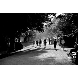 Schwarz-weiß-Aufnahme eines Parks, in dem viele Menschen joggen, spazierengehen oder auf einer Bank sitzen.