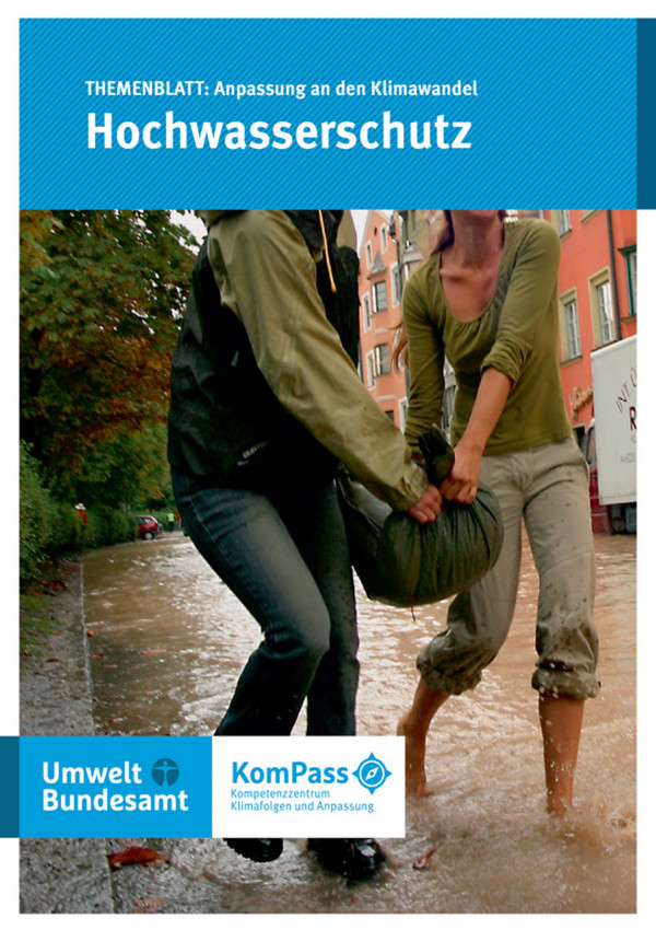 Cover von "Anpassung an den Klimawandel: Hochwasserschutz", Titelfoto: Zwei Frauen tragen gemeinsam einen Sandsack durch eine überflutete Straße