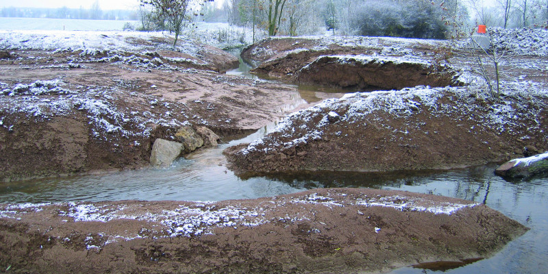 Foto: Der neu angelegte, stark geschwungene Verlauf der Wern in winterlicher Landschaft.