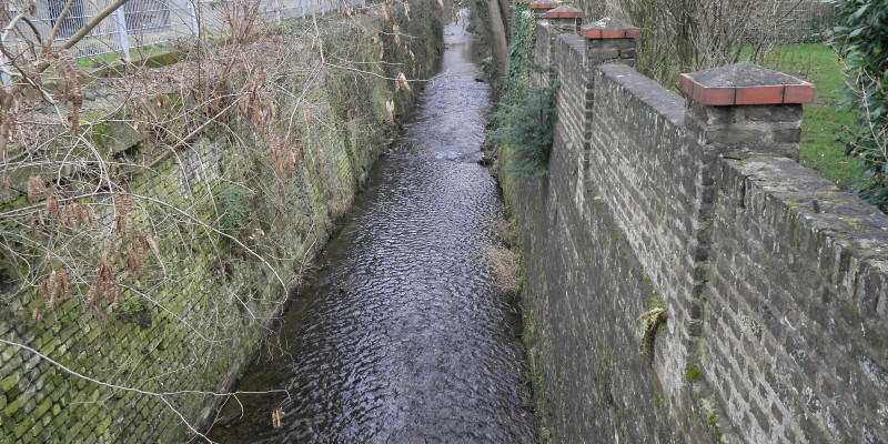 Foto: Der begradigte Godesberger Bach in Bonn, der an beiden Seiten mit über 3 m hohen Mauern eingefasst ist. 