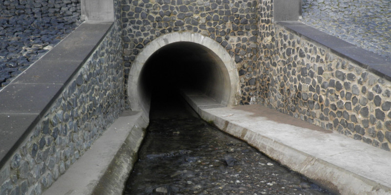 Foto: Eingang des Mehlemer Baches in ein Rohr. Ufer und Gewässersohle sind betoniert.