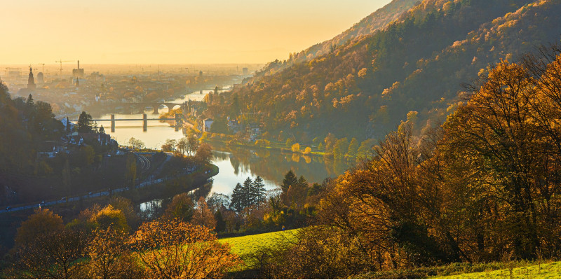 Das Bild zeit eine Landschaft mit Fluss und Bergen im Herbst