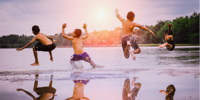 Children jump in a lake.
