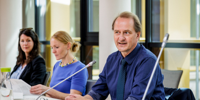 Das Bild zeigt Prof. Dr. Dirk Messner, den Präsidenten des Umweltbundesamtes. Dieser sitzt an einem Tisch und verfolgt den Ablauf der Jurysitzung. 